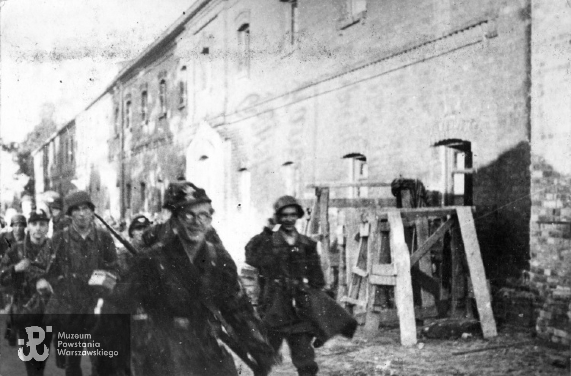 Powstanie Warszawskie - Wola. Porucznik "Halinka" prowadzi pluton "Topolnickiego" przez podwórze  "Twierdzy" - szkoły przy ul Okopowej 55a. Zdjęcie wykonano pomiędzy 3 a 7 sierpnia 1944 r. Fot. udostępnił  p. Bogusław Kostka 