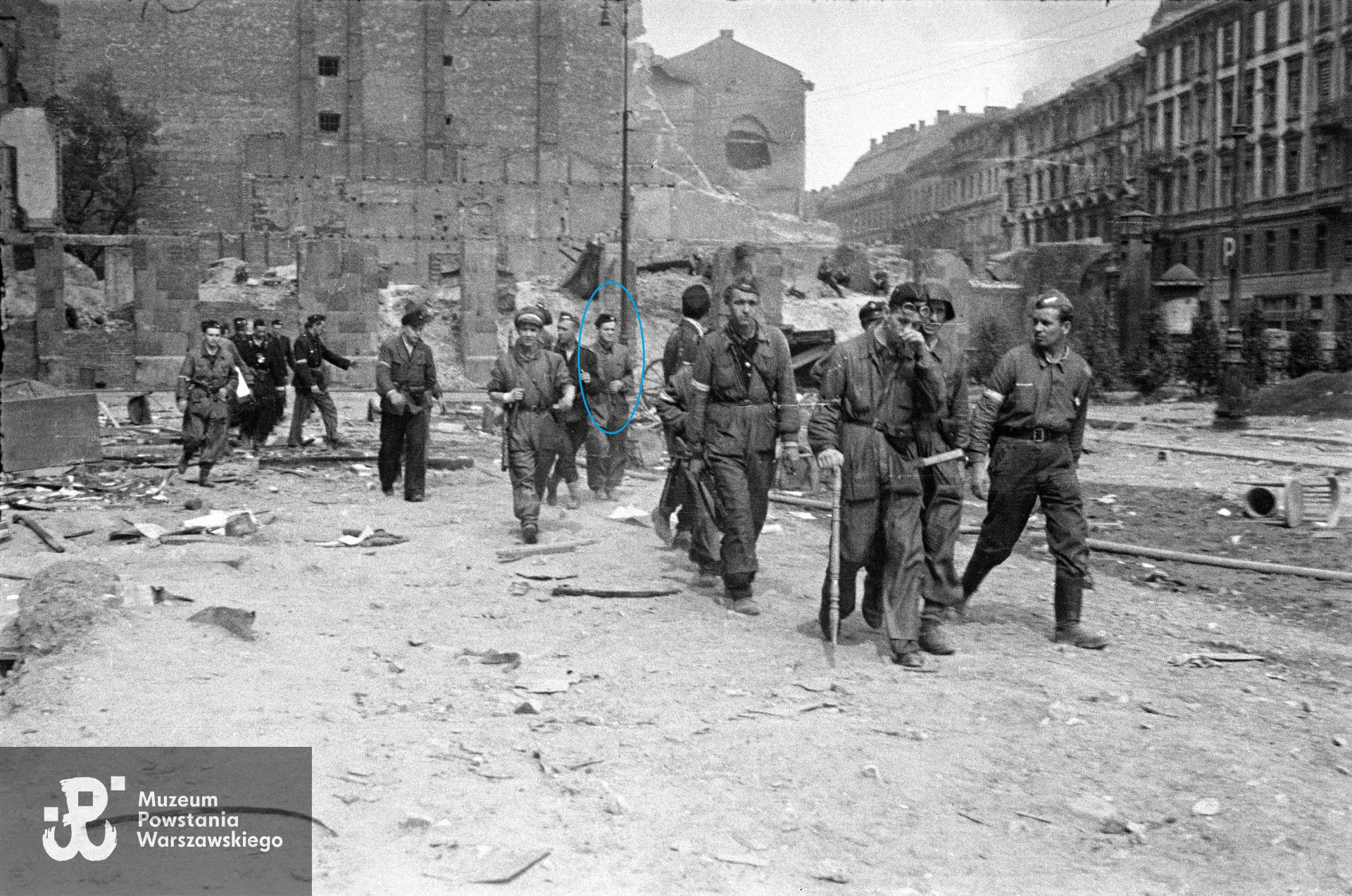 Fotografia  autorstwa Tadeusza Bukowskiego "Bończy" przedstawiająca Powstańców z grupy szturmowej por. Edwarda Garło ps. Kulesza (batalion "Kiliński" - 1. kompania "Wigry" )na Placu Napoleona.  W pierwszym rzędzie od lewej:  kpr. pchor. Bernard Zieliński „Połabski„, kpr. pchor. Edward Szczepan Mortko „Tumry” (w hełmie), por. Edward Garło „Kulesza„ W środku, na tle latarni, w berecie prawdopodobnie Zdzisław Jeske "Patyk" (zaznaczony kolorem niebieskim). W tle ruiny kamienicy przy Świętokrzyskiej 24/26, ściana boczna kamienicy przy Mazowieckiej 5 (?), kamienice przy Mazowieckiej od nr. 10 do nr. 2. Ze zbiorów Muzeum Powstania Warszawskiego sygn. MPW-IN/11900.Ujęcia tożsame: MPW-IH/5635, MPW-IK/1904, MPW-IP/5350, MPW-IP/9697,MPW-IV/2358, MPW-IV/2360.