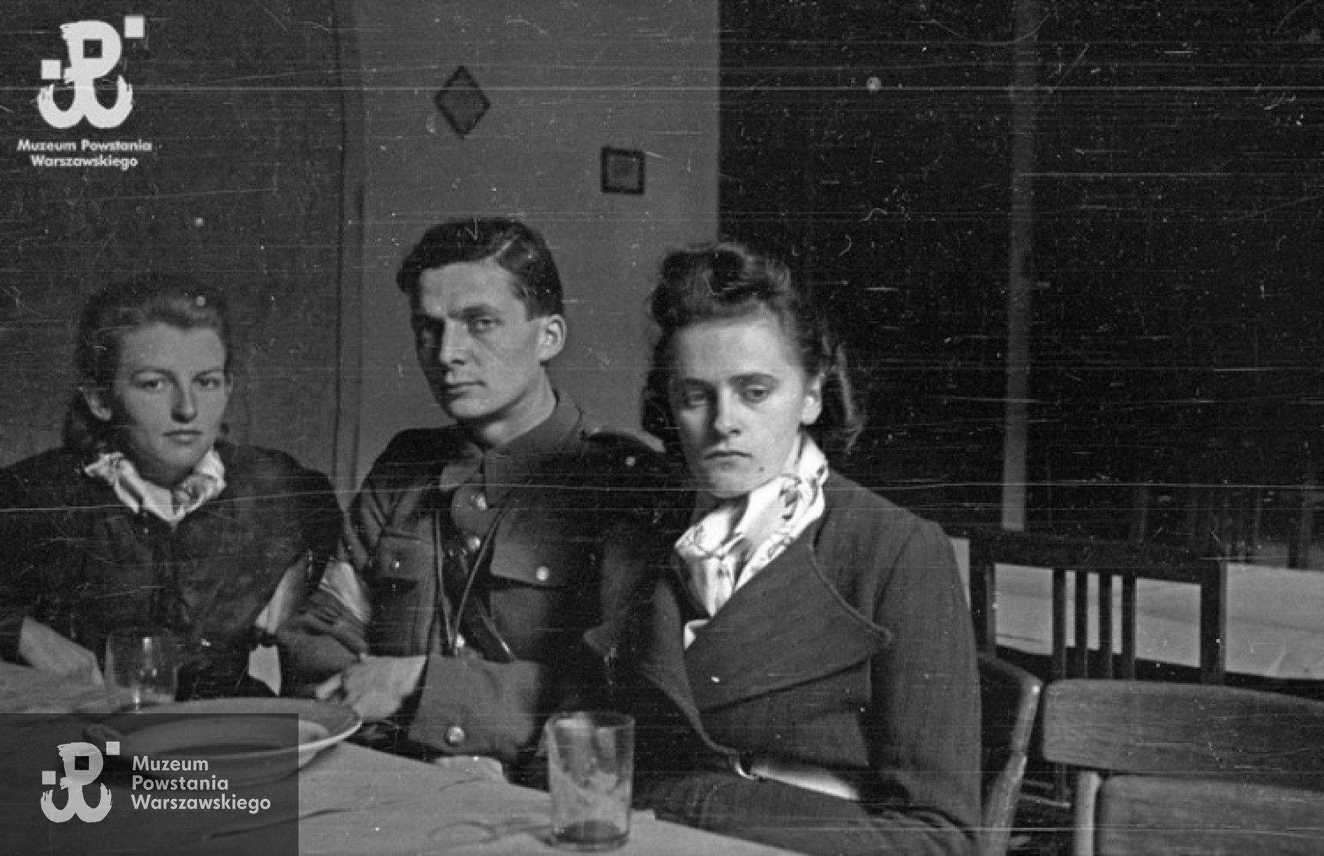Powstanie Warszawskie, wrzesień 1944 r. Posiłek powstańców z kompanii "Anna” batalionu "Gustaw” w kwaterze przy ulicy Jasnej 19. Przy stole od lewej: Danuta Magreczyńska "Danka”, por. Wojciech Sarnecki "Wojtek”, Janina Sanecka "Roma”.  Fot. Wiesław Chrzanowski "Wiesław", zbiory Fototeki MPW, sygn. MPW-IN/3324