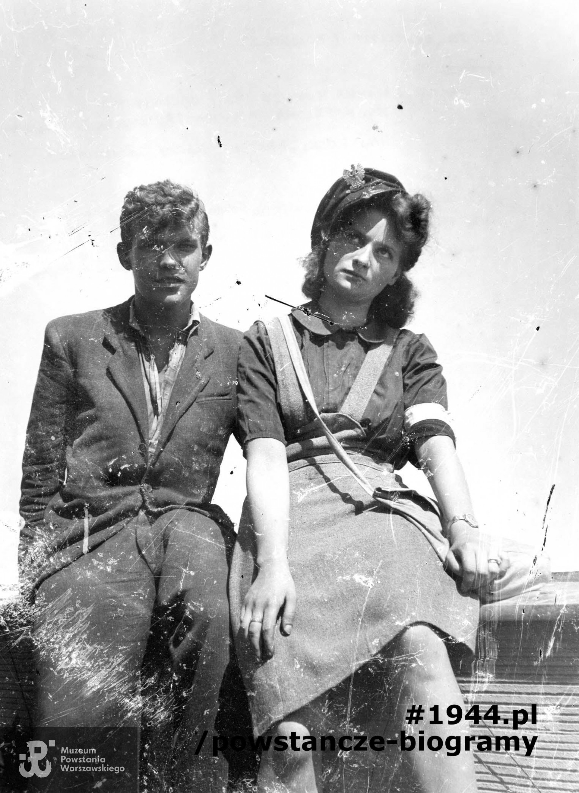 Fotografia z Powstania Warszawskiego -  kpr. pchor. Jan Rocki "Bratek" i Anna Hołubowicz (Gadkowska) na dachu domu przy ul. Mickiewicza 34. Fot. autorstwa Stefana Lewandowskiego ze zbiorów Fototeki Muzeum Powstania Warszawskiego sygn. MPW-IP/3509. Ujęcie tożsame: sygn. MPW-IH/1581