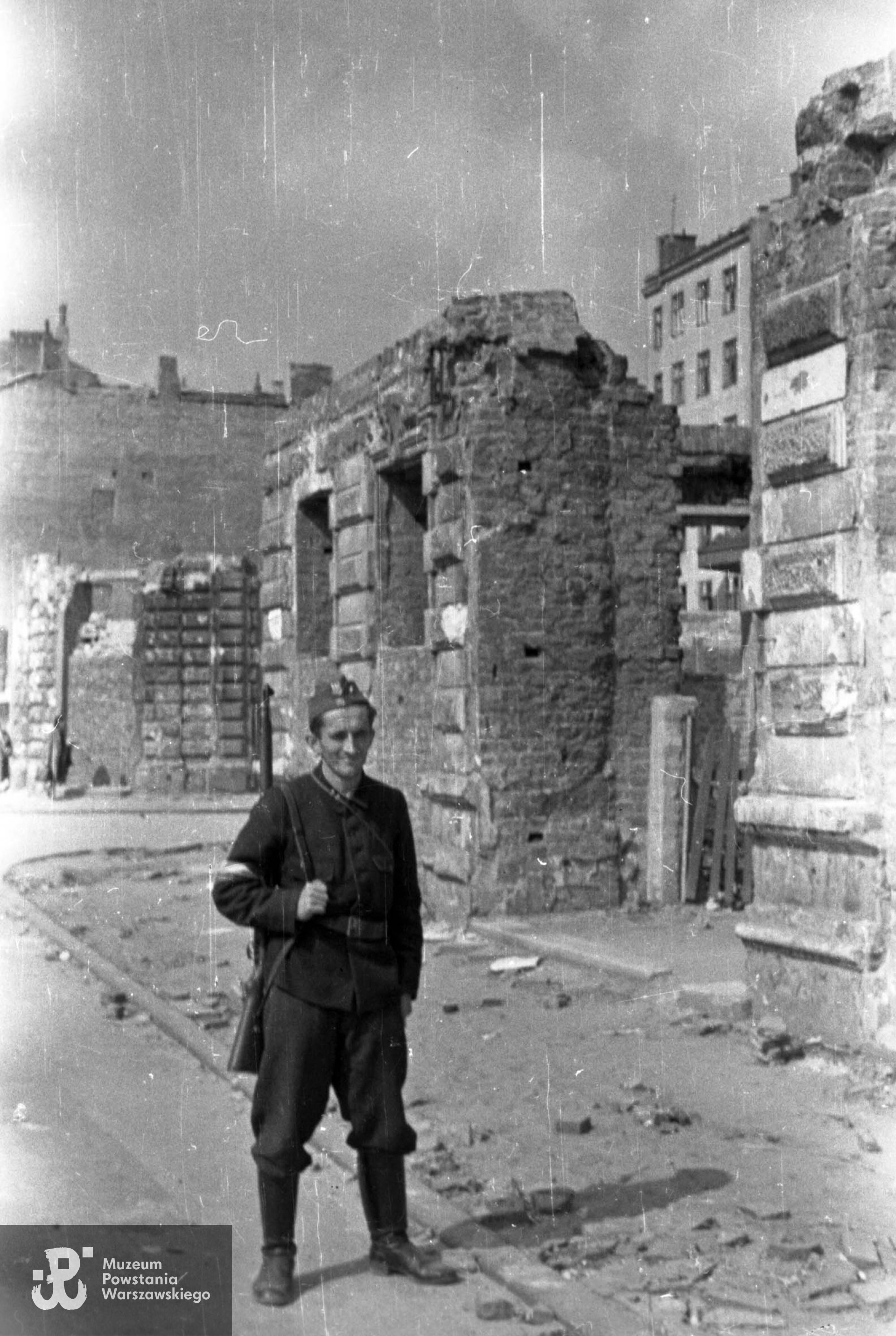 Kpr. pchor. Stanisław Wład "Tarnowski" z pułku NSZ im. gen. Władysława Sikorskiego na ul. Czackiego, na tle narożnej kamienicy nr 2 u zbiegu ze Świętokrzyską. Autorem zdjęcia jest Jerzy Kokczyński "Boczkowski". Fot. ze zbiorów Muzeum Powstania Warszawskiego,  sygn. MPW-IN/3470