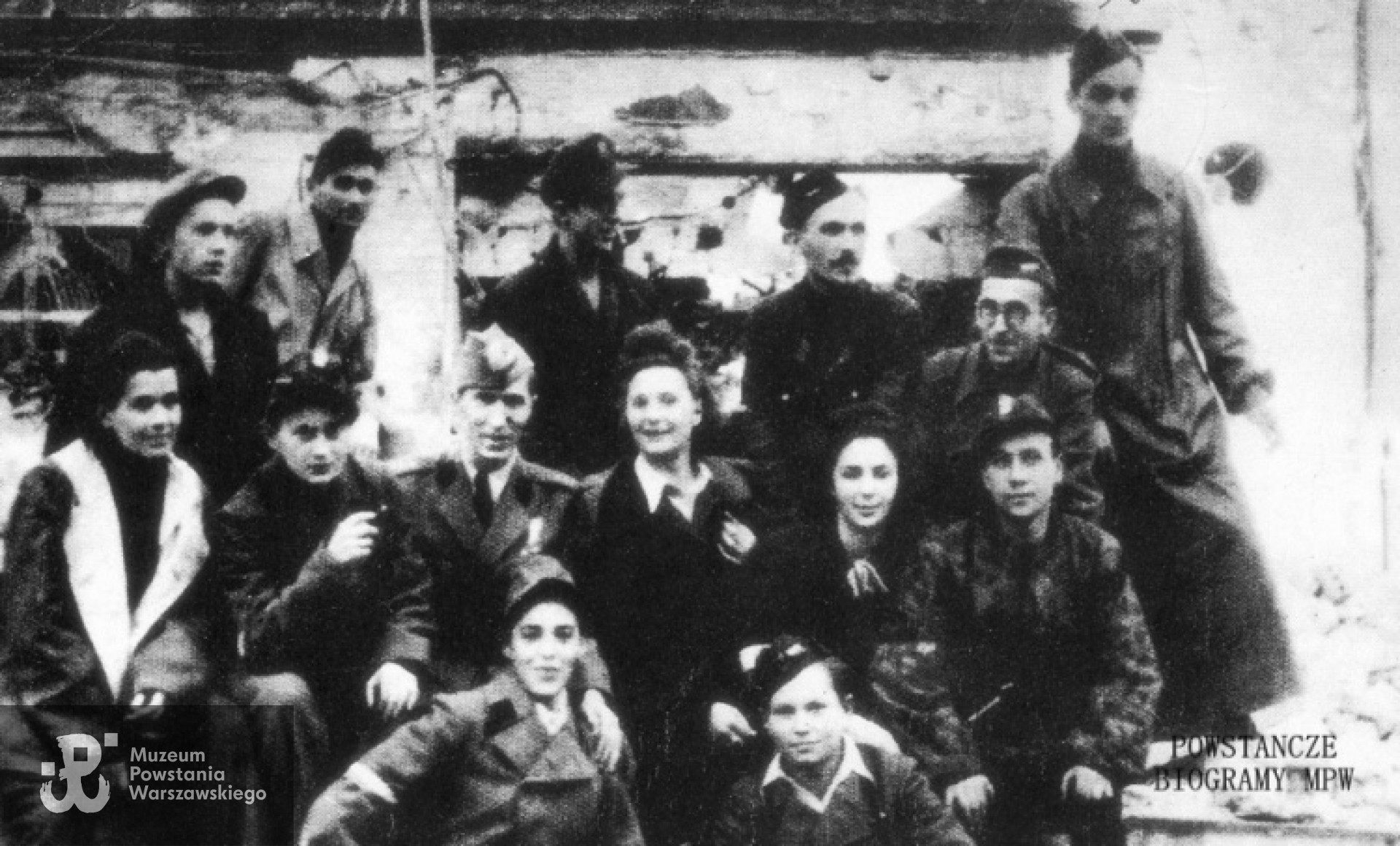 Od lewej : u dołu "Wanda". "Jurek". Siedzą : "Janka". ppor. Elżbieta Grossówna - Ostrowska "Ela", kpt. "Fon", "Krysia", "Danusia", "Czujny". Stoją "Krzysztoszek", "Dąb", "Kacprzyk", "Śremski", "Żuk"  i Stanisław Oleksiak "Kruk". Fot. archiwum rodzinne / materiały do Słownika Uczestników PW