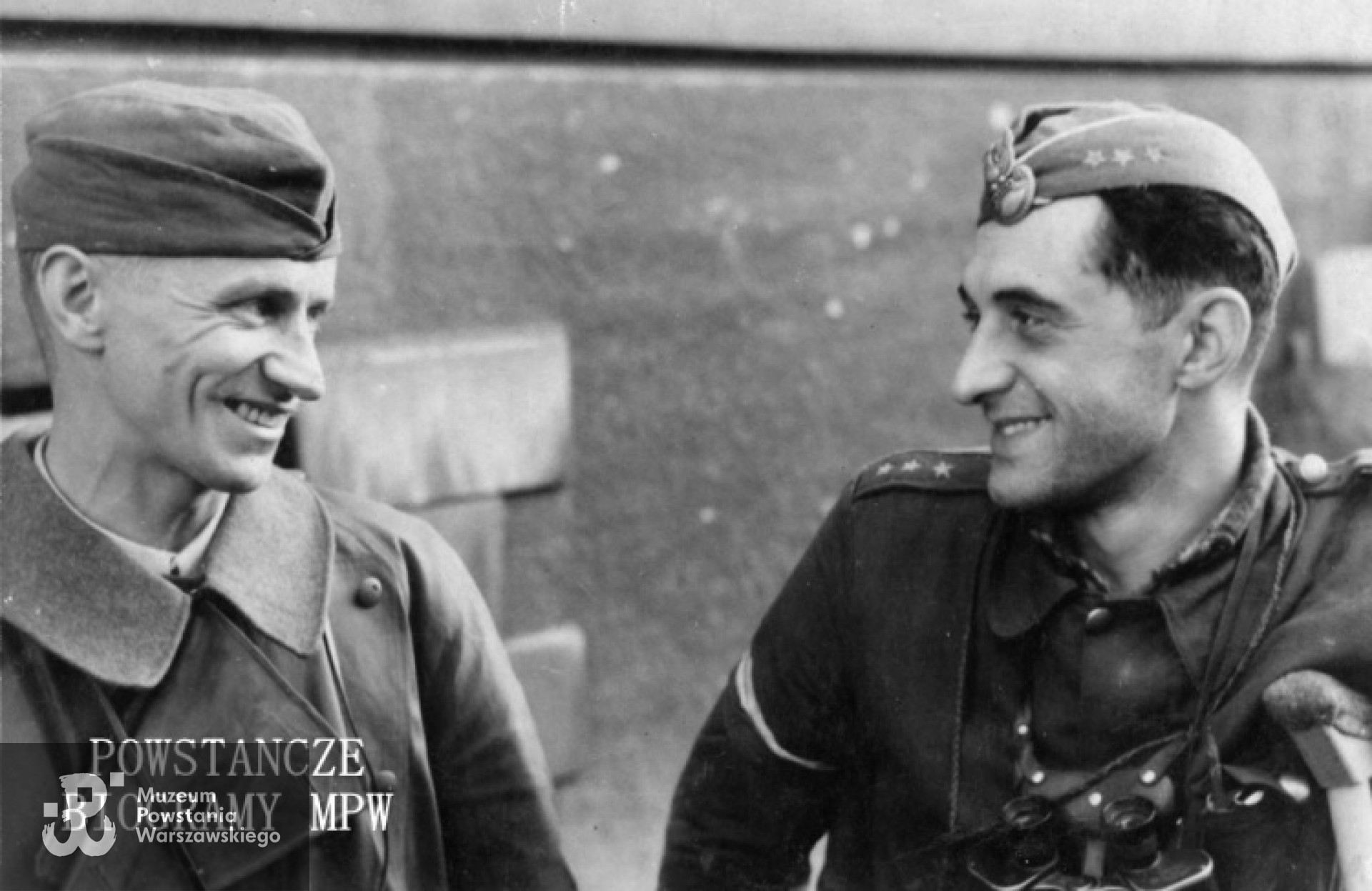 Fotografia z Powstania Warszawskiego. Śródmieście Północne. Od lewej: kpt. Tadeusz Przystojecki "Lech Żelazny" - dowódca I batalionu zgrupowania Chrobry II i kpt. Konstanty Mieczysław Zacharewicz "Zawadzki" - dowódca I kompanii "Warszawianka" tegoż zgrupowania. Zdjęcie wykonane na tle Domu Kolejowego. Fot. ze zbiorów Muzeum Powstania Warszawskiego, sygn. MPW-IP/2420