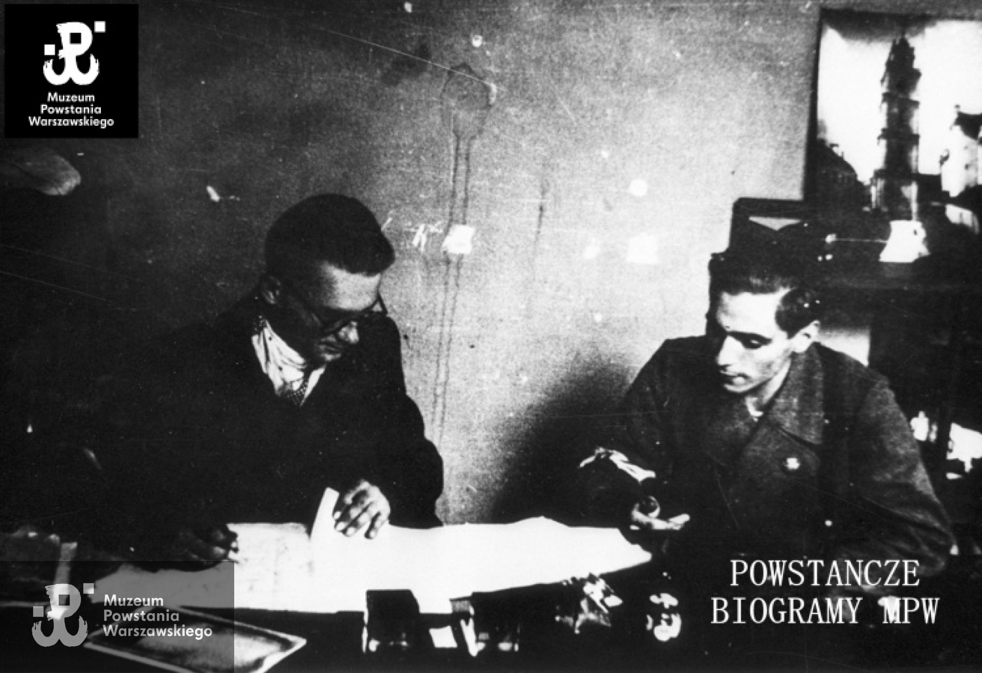 Fotografia z Powstania Warszawskiego. Stare Miasto, plac Krasińskich. W redakcji powstańczej gazetki. Bliższe miejsce nieustalone. Jest to ostatnie zdjęcie por. Jerzego Zborowskiego "Jeremi" ze sztabu batalionu "Parasol" (po lewej). Po prawej, dowódca 2. kompanii batalionu "Parasol"- ppor. Jerzy Zapadko "Mirski". Ze zbiorów Muzeum Powstania warszawskiego, sygn. MPW-IH/5308. Autor: Tadeusz Garliński