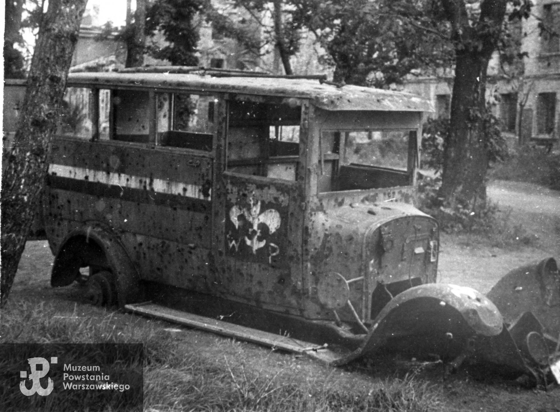 Fotografia autorstwa Zbigniewa Grochowskiego.Warszawa, 1945 rok, wrak samochodu Harcerskiej Poczty Polowej w Ogrodzie Krasińskich. Fot. ze zbiorów Muzeum Powstania Warszawskiego, sygn. MPW-IP/2721 (MPW-GI-4000/15/06)