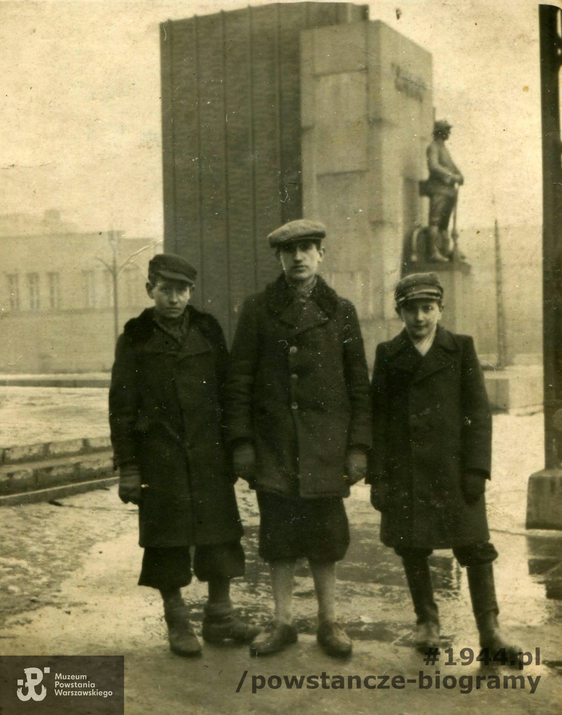 Wiosna 1943 roku. Pierwszy od lewej to Kazimierz Senczek, w środku Zbigniew Wasilewski. Najniższy chłopiec miał na imię Józef,  nazwiska nieustalone. W tle widoczny Pomnik Poległym Saperom – (pomnik znajdujący się w latach 1933–1944 u zbiegu ulic Topolowej  i 6 sierpnia, w 1944 roku zniszczony przez Niemców.) Fot. z archiwum rodzinnego p. Kazimierza Senczka
