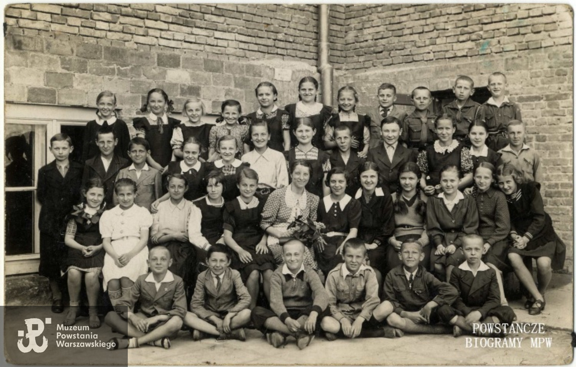 Uczniowie V klasy szkoły powszechnej przy ul. Sieradzkiej we Włochach pod Warszawą - Stanisław Grzeliński  "Rybka" siedzi w pierwszym rzędzie (na ziemi) II z prawej strony. Pośrodku wychowawczyni - p. Zielonkówna. Fot. z archiwum Stanisława Grzelińskiego.