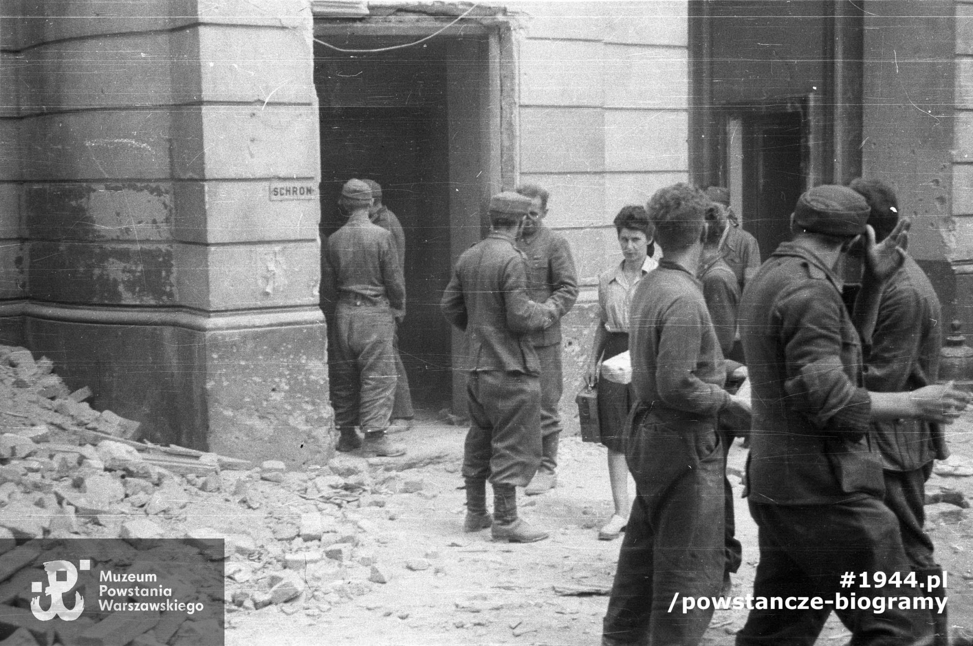 Powstanie Warszawskie, 26.08.1944 - Stare Miasto, ulica Kilińskiego. Podwórze domu przy ulicy Kilińskiego 3, mieszczącego szpital batalionu "Gustaw”. Grupa jeńców niemieckich zatrudnionych przy odgruzowywaniu zasypanych po bombardowaniu. Pomiędzy jeńcami łączniczka Janina Sarnecka "Janeczka” z kompanii "Anna”. Fot. autorstwa Wiesława Chrzanowskiego ps. "Wiesław" ze zbiorów fototeki MPW, sygn. <a href=" http://www.1944.pl/galerie/fototeka/foto/3175/?szukaj=jeńcy"> MPW-IN/3223</a>