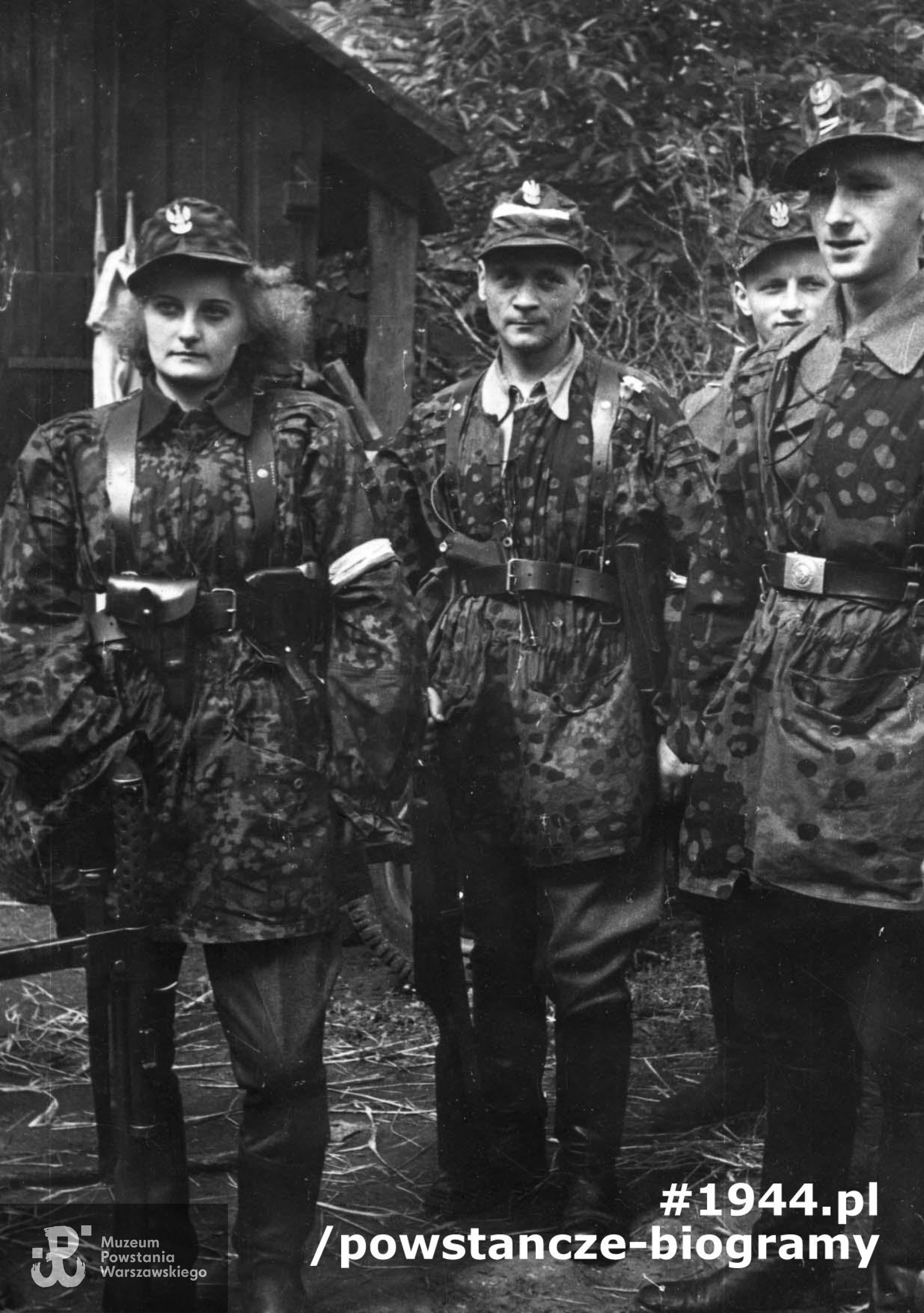 Fotografia z Powstania Warszawskiego. Wola, ul. Okopowa. Wola. Powstańcy ze Zgrupowania "Radosław" w ogrodzie przy siedzibie RGO - ul. Okopowa 41. Pierwszy z prawej kpr. pchor. Lech Rytarowski "Topór", w środku  kpr. Zygmunt Siennicki "Bór", obok niego łączniczka Irena Wnęk-Kulczycka "Irys". Fot. zbiorów Muzeum Powstania Warszawskiego, sygn. MPW-IP/7476