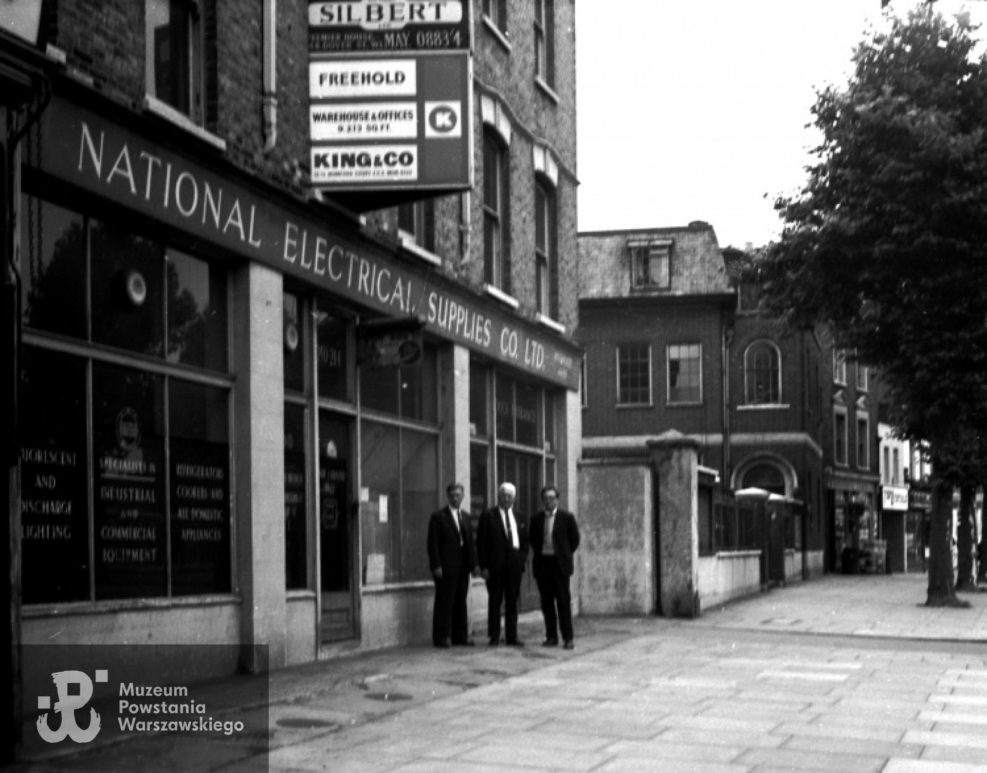 Prezydium Zarządu Polskiego Ośrodka Sołeczno-Kulturalnego na tle posesji, na której miejscu stoi obecnie budynek POSK. Od lewej stoją: inż. Czesław Woyno - Sekretarz, prof. inż. Roman Wajda - Prezes, inż. Krzysztof Głuchowski - Skarbnik. Londyn, wrzesień 1968 rok. Fot. z archiwum rodzinnego Krzysztofa Głuchowskiego.