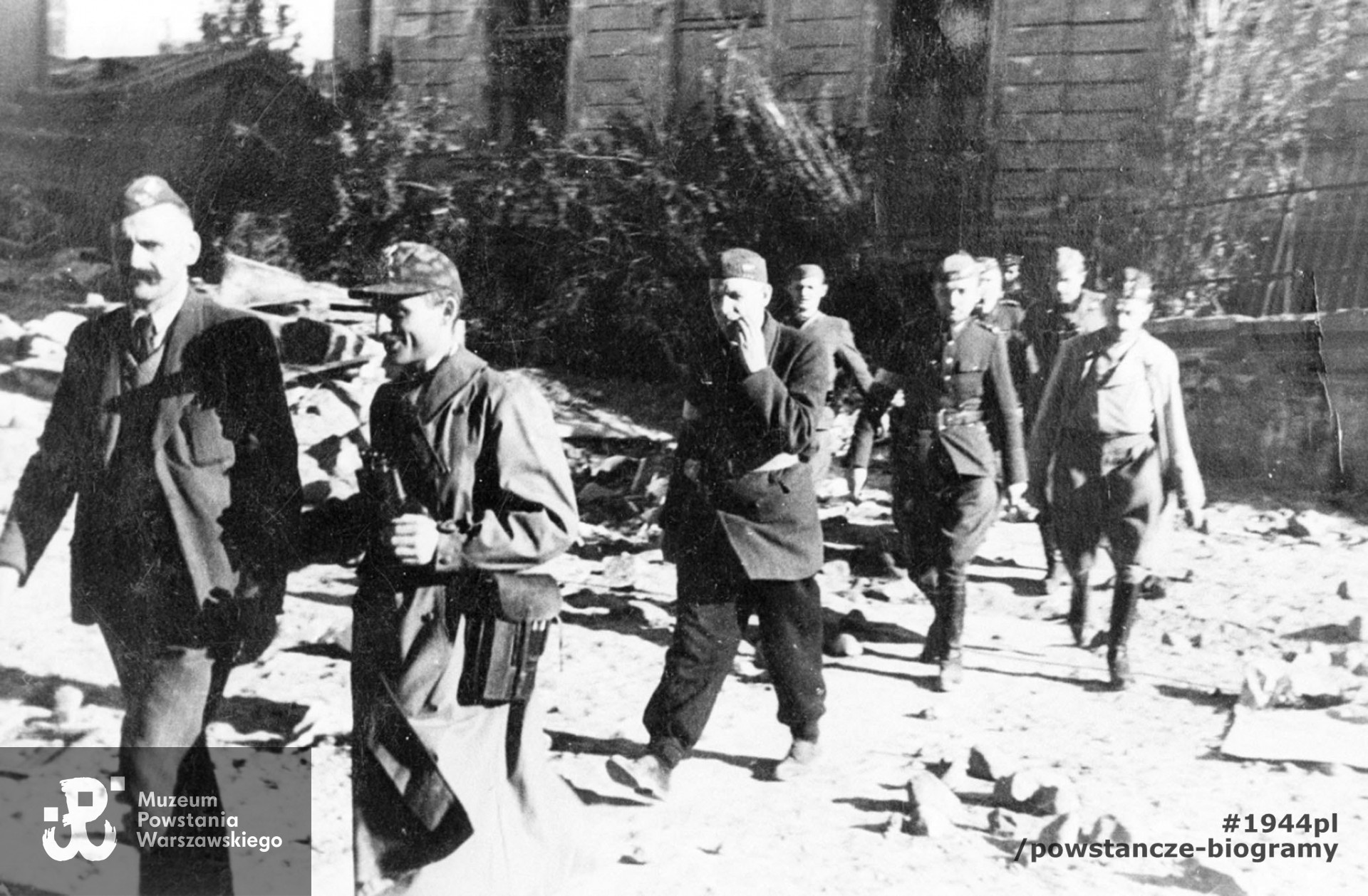 Fotografia z Powstania Warszawskiego. Dowództwo Zgrupowania, drugi od lewej idzie kpt. Wacław Stykowski "Hal". Fot. ze zbiorów Muzeum Powstania Warszawskiego, sygn.  MPW-IH/3926
