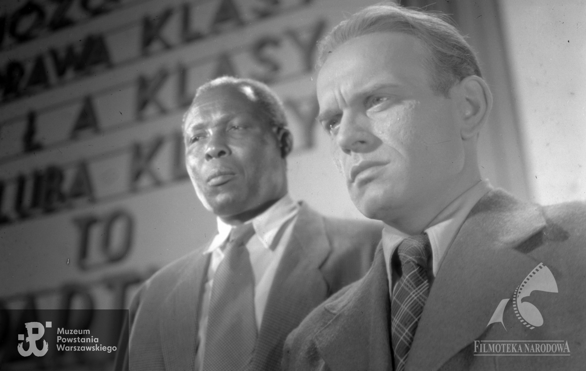 „Żołnierz Zwycięstwa" w reż. Wandy Jakubowskiej (1953). Na zdjęciu widoczni -  August Agbola O'Brown i Peter Marx. Fotografia ze zbiorów Filmoteki Narodowej - Instytut  Audiowizualny, - Studio Filmowe ”Kadr", autor Kazimierz  Wawrzyniak  <strong><i> fototeka.fn.org.pl</i></strong>. Identyfikacja  - p. Piotr Śmiałowski, FINA