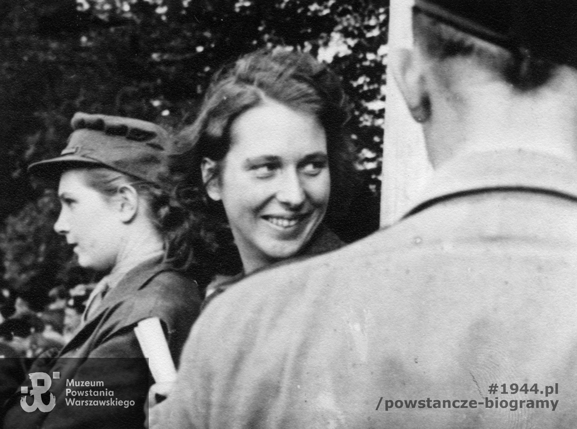 Fotografia z obozu byłych jeńców wojennych w Niederlangen wykonana między majem a wrześniem 1945 roku. Krystyna Hildebrandt "Ina" (w środku), która po Powstaniu Warszawskim przebywała w niemieckiej niewoli w Stalagu VI C,  [prawdopodobnie] podczas wizyty gen. Tadeusza Komorowskiego "Bora" w obozie b. jeńców wojennych. Fot. ze zbiorów Muzeum Powstania Warszawskiego, sygn. MPW-IP/6045, dar Emilii Hildebrandt