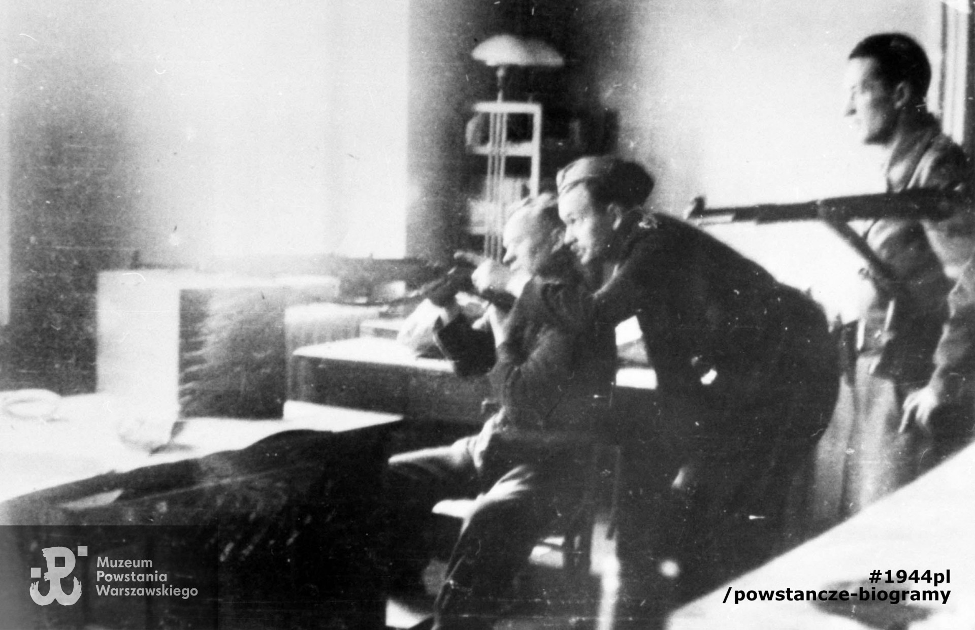 Fotografia z Powstania Warszawskiego. Kpt. Józef Roman "Ziuk", dowódca kompanii (na zdjęciu w środku) z żołnierzami ze swojego zgrupowania, na stanowisku ogniowym w budynku przy ul. Wiejskiej. Fot. ze zbiorów Muzeum Powstania Warszawskiego, sygn. MPW-IN/3523. Autorem zdjęcia jest Henryk Świercz "Świerszcz".