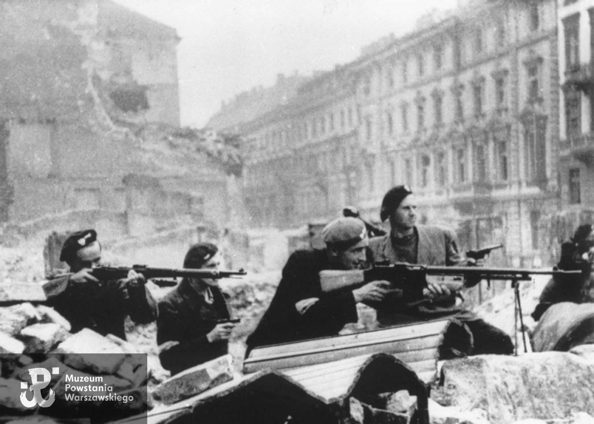 Sierpień 1944 r. - barykada na skrzyżowaniu ulic Świętokrzyskiej i Mazowieckiej, widziana od strony pl. Napoleona. Marian Korzekwa na zdjęciu pierwszy z prawej. Fot. z archiwum rodzinnego.