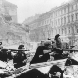 Sierpień 1944 r. - barykada na skrzyżowaniu ulic Świętokrzyskiej i Mazowieckiej, widziana od strony pl. Napoleona. Marian Korzekwa na zdjęciu pierwszy z prawej. Fot. z archiwum rodzinnego.
