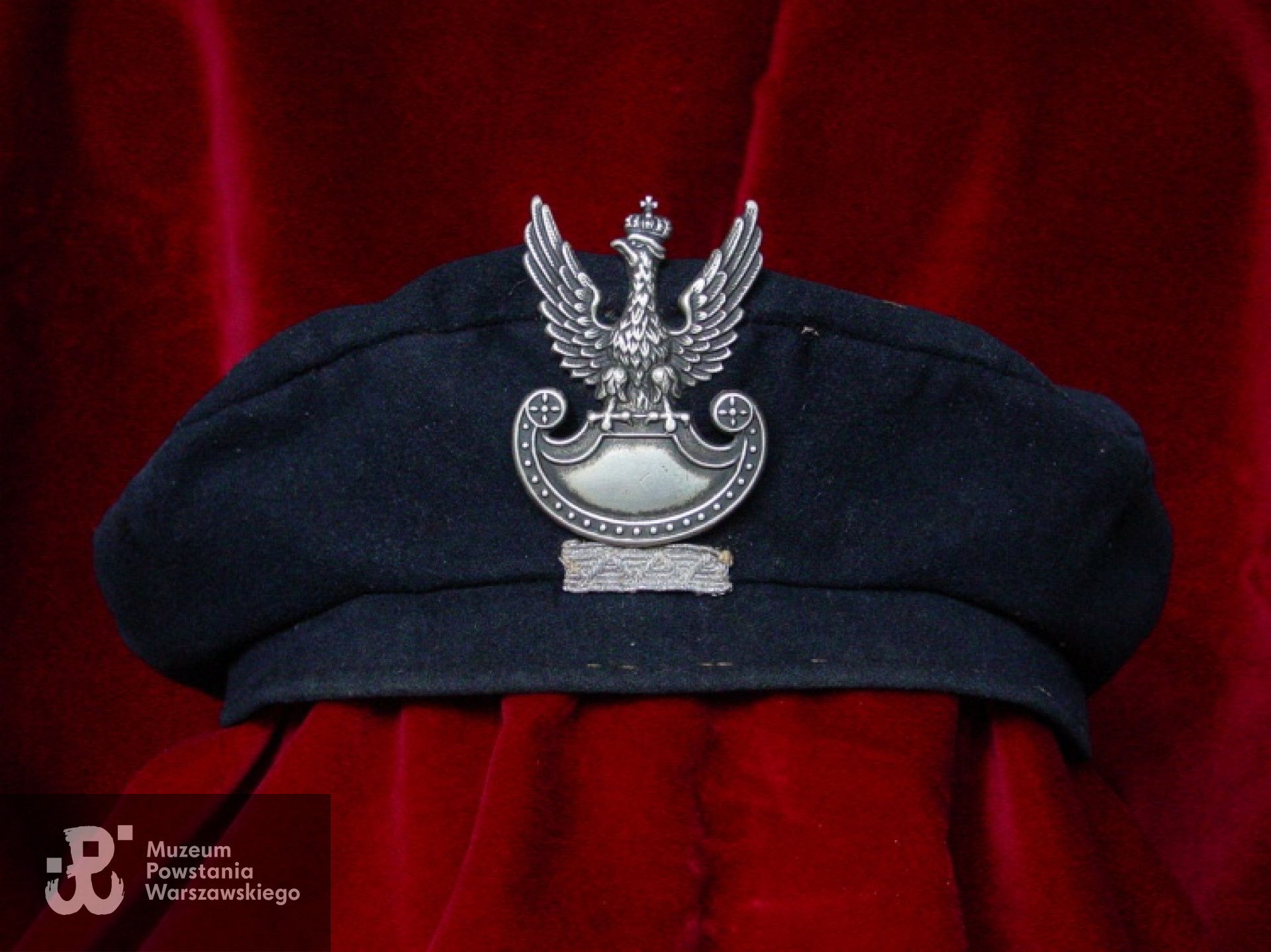 Powstańczy beret Krzysztofa Głuchowskiego z plutonu 1112. Początkowo umundurowanie uzupełniał szary kombinezon i skórzany pas wojskowy. Po zdobyciu przez Kedyw "Kolegium A" magazynów na Stawkach, pluton otrzymał niemieckie szare mundury pancerne z krótkimi kurtkami oraz skórzane szelki szturmowe z ładownicami. Z archiwum rodzinnego Krzysztofa Głuchowskiego.