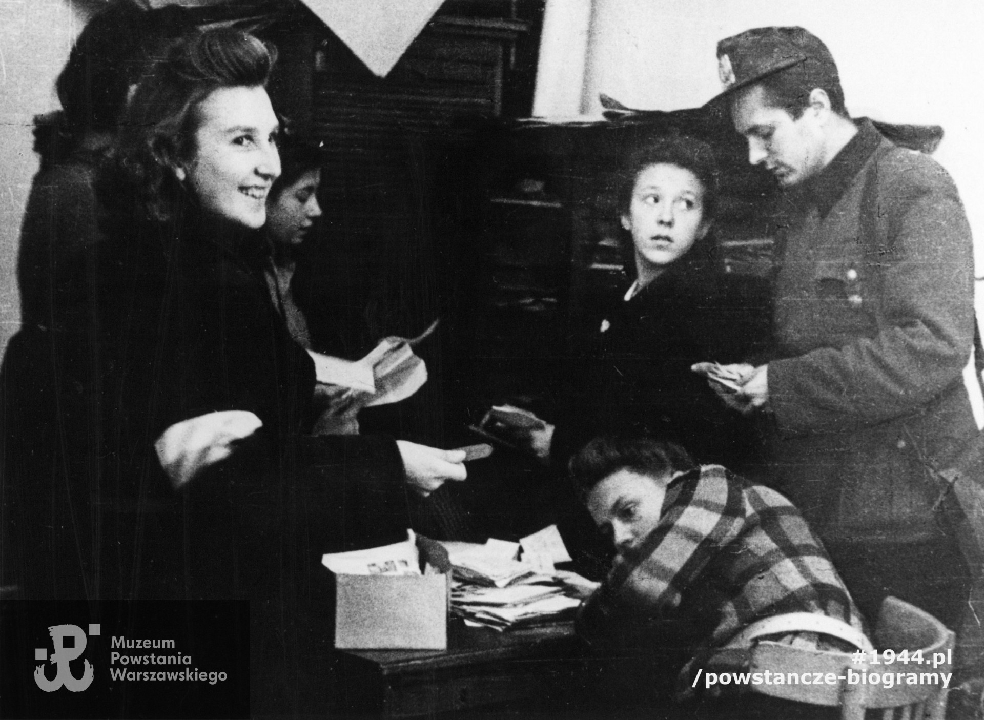 Fotografia z Powstania Warszawskiego, sortowanie listów w siedzibie Głównej Poczty Polowej przy ul. Świętokrzyskiej 28. Po prawej komendant HPP Przemysław Górecki "Kuropatwa". Fot. ze zbiorów Muzeum Powstania Warszawskiego, sygn. P/3982-198, zbiór Jadwigi Podrygałło, z d. Tomaszewskiej ps.„Isia”, „Szczeniak".