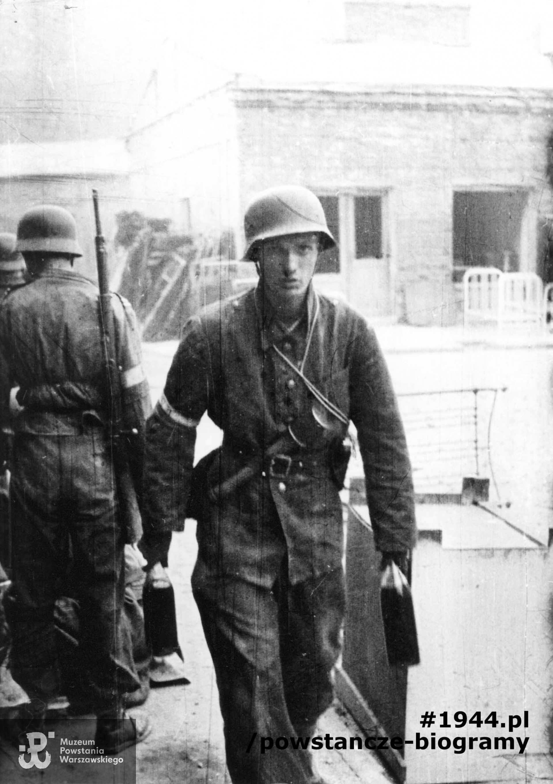 Fotografia z Powstania Warszawskiego. Śródmieście Północne. Powstańcy na terenie bazaru Pociejów na tyłach PAST-y, między ulicami Zielną i Bagno. Na pierwszym planie kpr. pchor. Jan Gozdawa-Gołębiowski "Dziryt" z I plutonu kompanii "Koszta" z butelkami zapalającymi. Fot. ze zbiorów Muzeum Powstania Warszawskiego, sygn. MPW-IN/557. Autorem zdjęcia jest Eugeniusz Lokajski ps. "Brok"