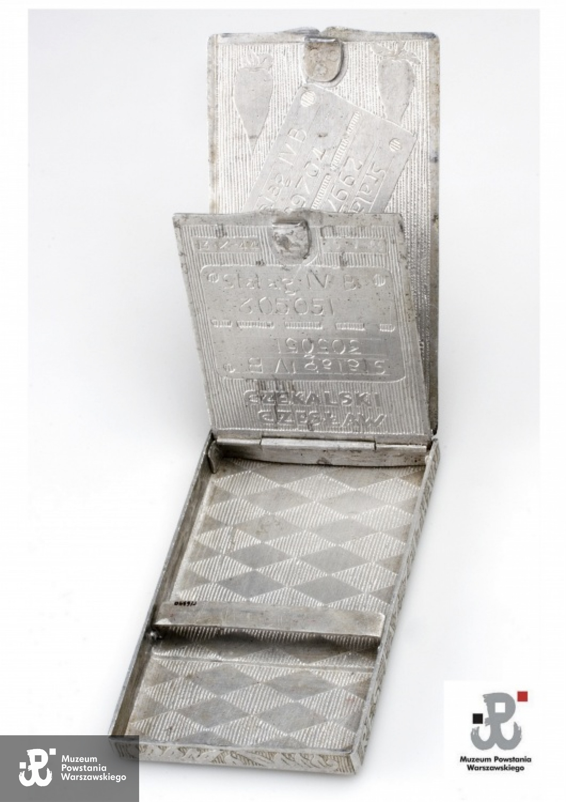 Papierośnica wykonana z menażki w obozie Zeithain przez Czesława Czekalskiego dla przyszłej żony - Zofii Sosnowskiej, obecnie Czekalskiej.  Wewnątrz odtworzone blaszki identyfikacyjne Czesława i Zofii o numerach 305051 i  299704. Ze zbiorów Muzeum Powstania Warszawskiego - dar Zofii Czekalskiej ps. "Sosenka"