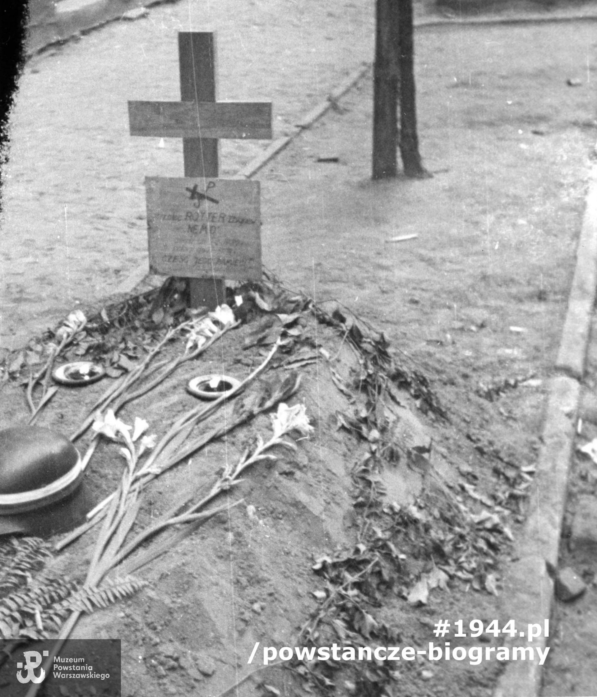 Fotografia z Powstania Warszawskiego. Śródmieście Północne. Ul. Boduena. Grób kpr. pchor. Zbigniewa Rottera "Nemo" z 163 plutonu 1. kompanii "Wigry" batalionu "Kiliński", zmarłego wskutek odniesionych ran  17 sierpnia 1944. Na grobie kwiaty i hełm z biało-czerwoną opaską. Autorem zdjęcia jest Joachim Joachimczyk "Joachim". Fot. ze zbiorów Muzeum Powstania Warszawskiego, sygn. MPW-IP/852
