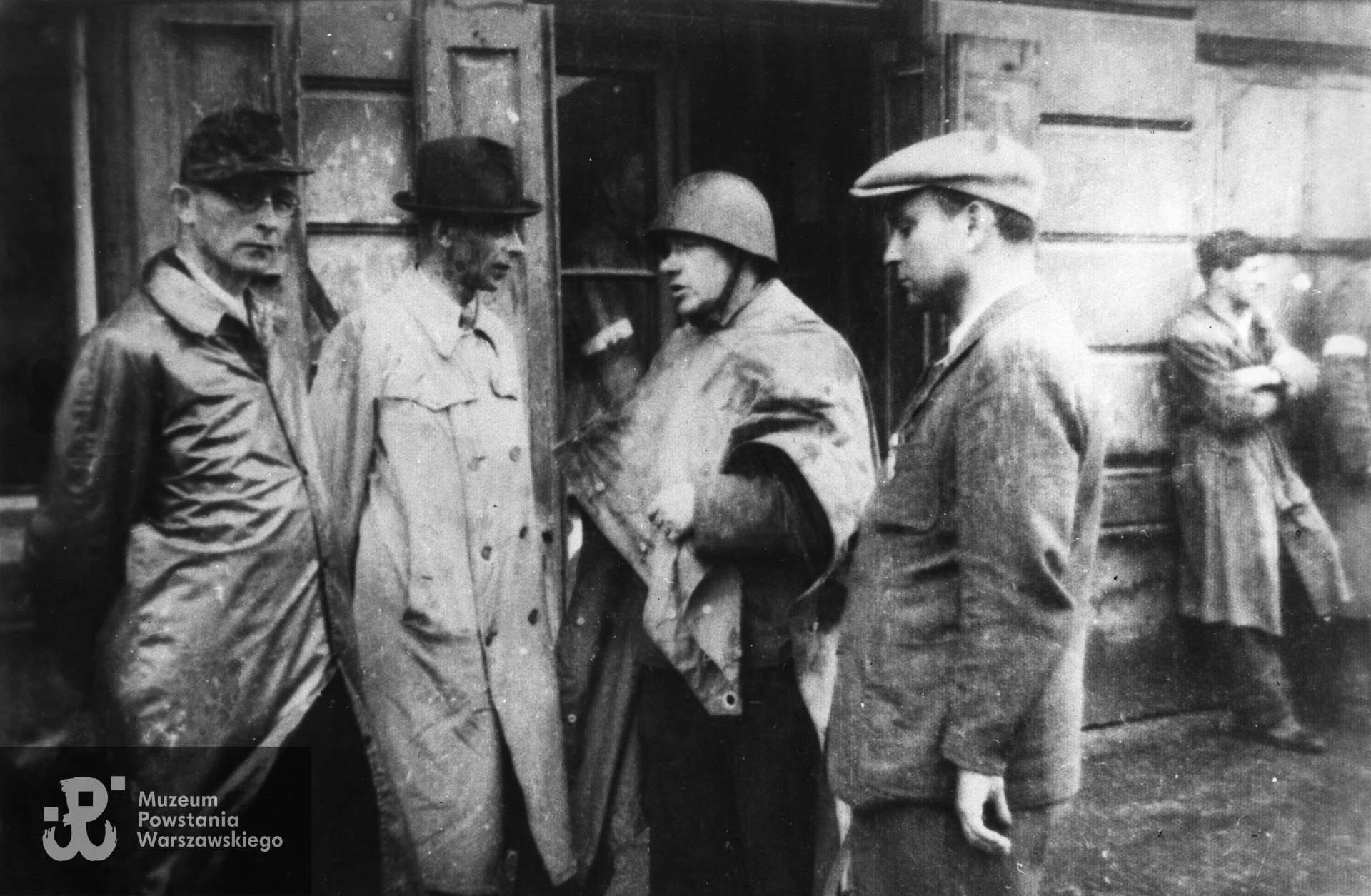 Fotografia z Powstania Warszawskiego. Wola. Inspekcja oddziałów "Radosława" w okolicach ul. Mireckiego. Od lewej : mjr  Wacław Janaszek "Bolek" (szef sztabu "Radosława"), gen. Tadeusz Komorowski "Bór", płk Jan Mazurkiewicz "Radosław" i kpt. Ryszard Krzywicki "Szymon" (adiutant "Bora"). Fot. ze zbiorów Muzeum Powstania Warszawskiego, sygn. MPW-IK/1267