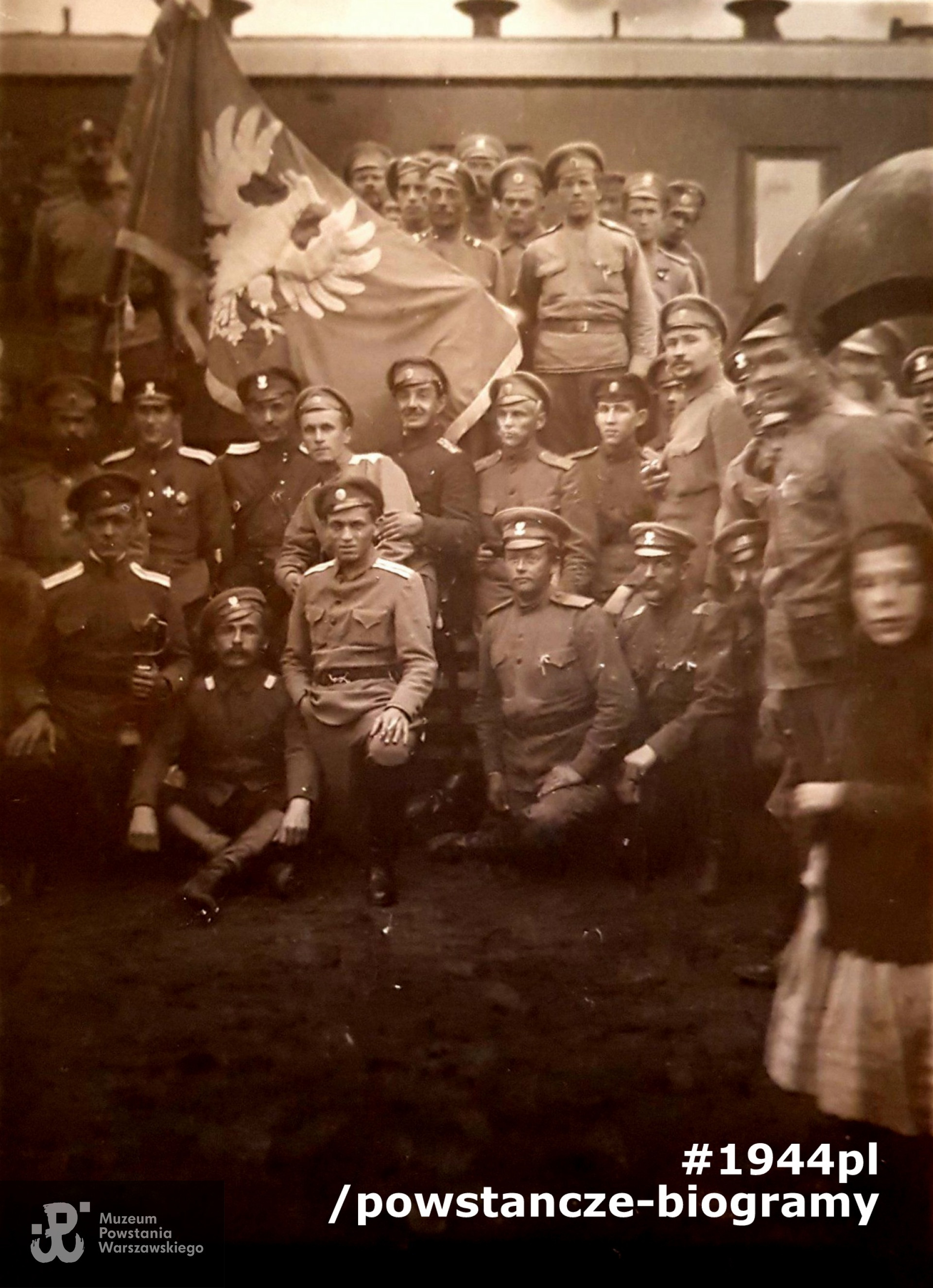 Zdjęcie Wacława, ojca Henryka Apanosowicz Katłu-beja po odzyskaniu niepodległości. Żołnierze,  jeszcze w mundurach armii rosyjskiej trzymają polski sztandar z orłem. Wacław widoczny w drugim rzędzie, czwarty od lewej. Fot. z archiwum rodzinnego udostępniona przez p. Olgę Apanosowicz Katłu-bej