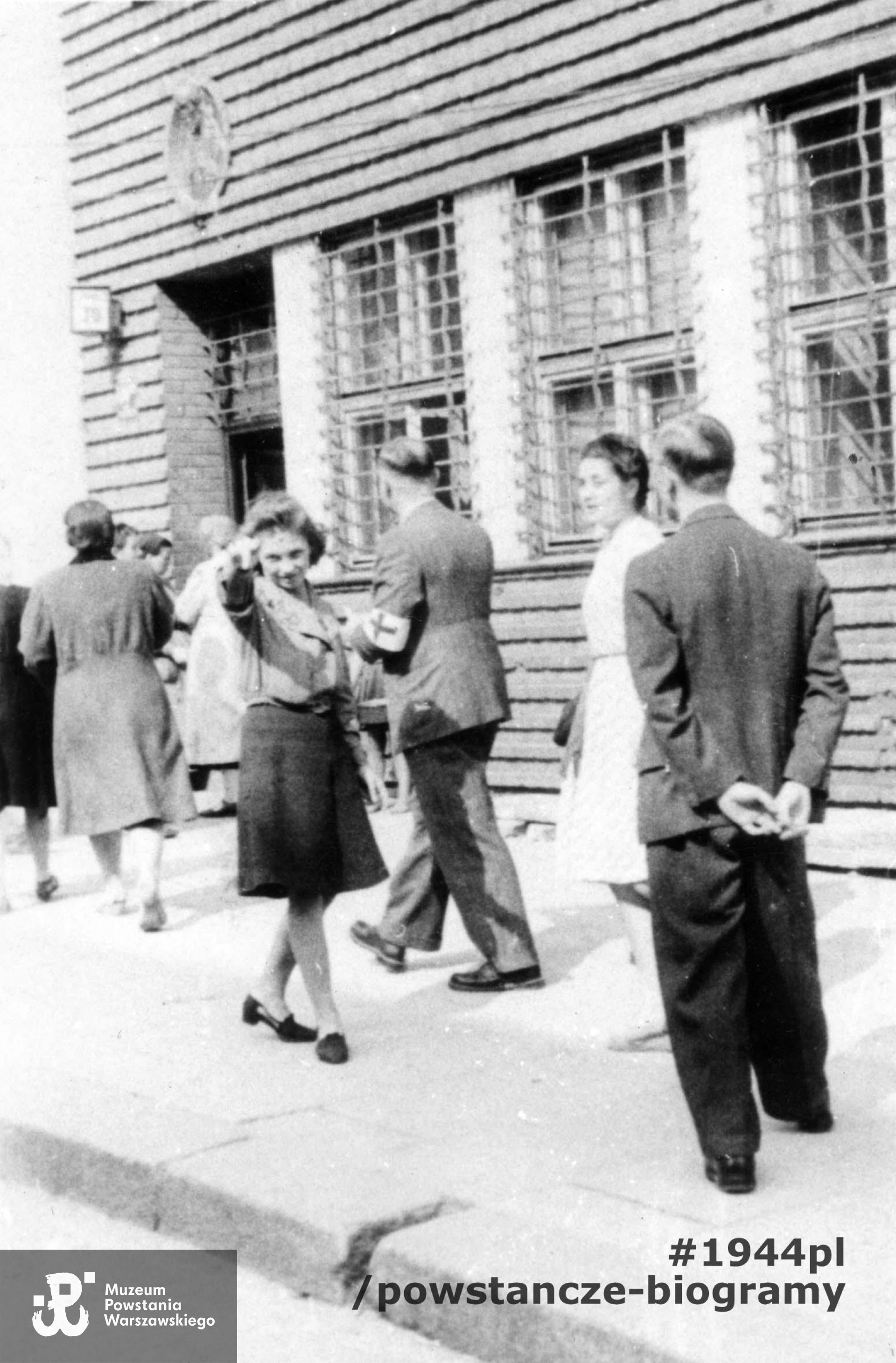 Fotografia z Powstania Warszawskiego. Powiśle. Przed szpitalem polowym Grupy Bojowej "Krybar" w budynku przy ulicy Tamka 30. Z tyłu w opasce z czerwonym krzyżem doktor Jerzy Rowiński "Jurand", porucznik korpusu sanitarnego, szef sanitarny IV Rejonu Obwodu Wojskowej Służby Ochrony Powstania. W białym kitlu sanitariuszka Barbara Szuladzińska "Wanda". Fot. ze zbiorów Muzeum Powstania Warszawskiego, sygn. MPW-IP/2013