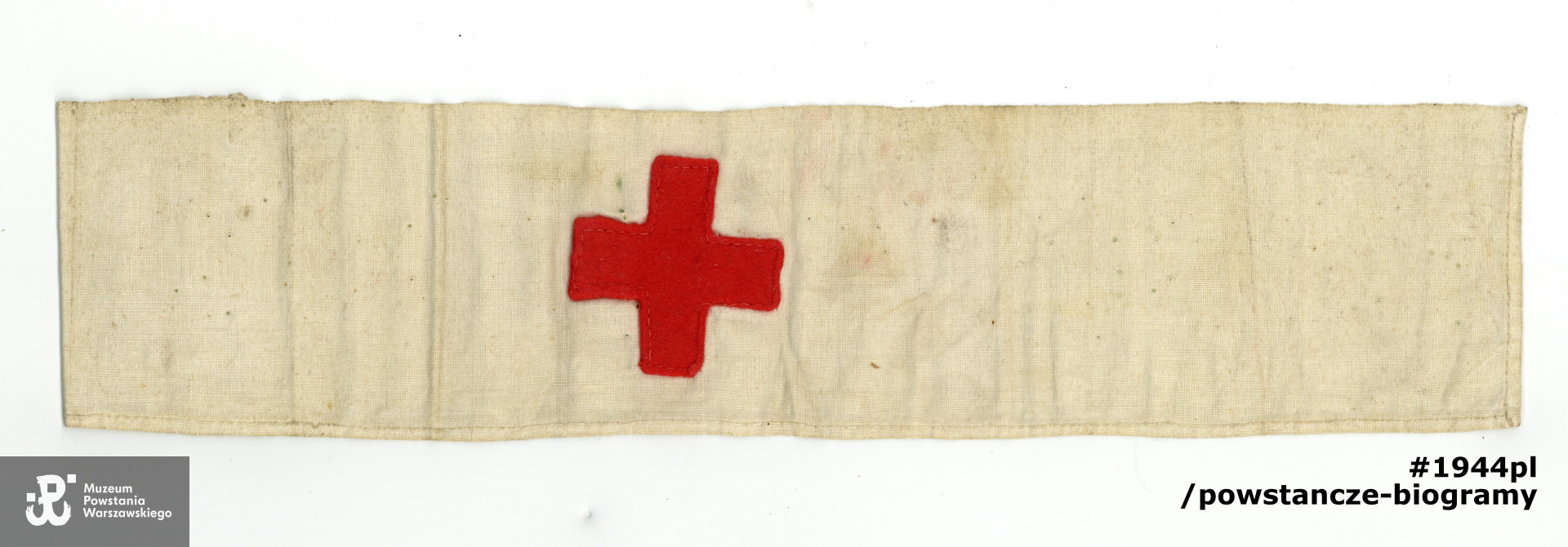 Opaska sanitarna z czerwonym krzyżem należąca do Anny Budzyńskiej z d. Chyckiej. Ze zbiorów Muzeum Powstania Warszawskiego, sygn. P/9308