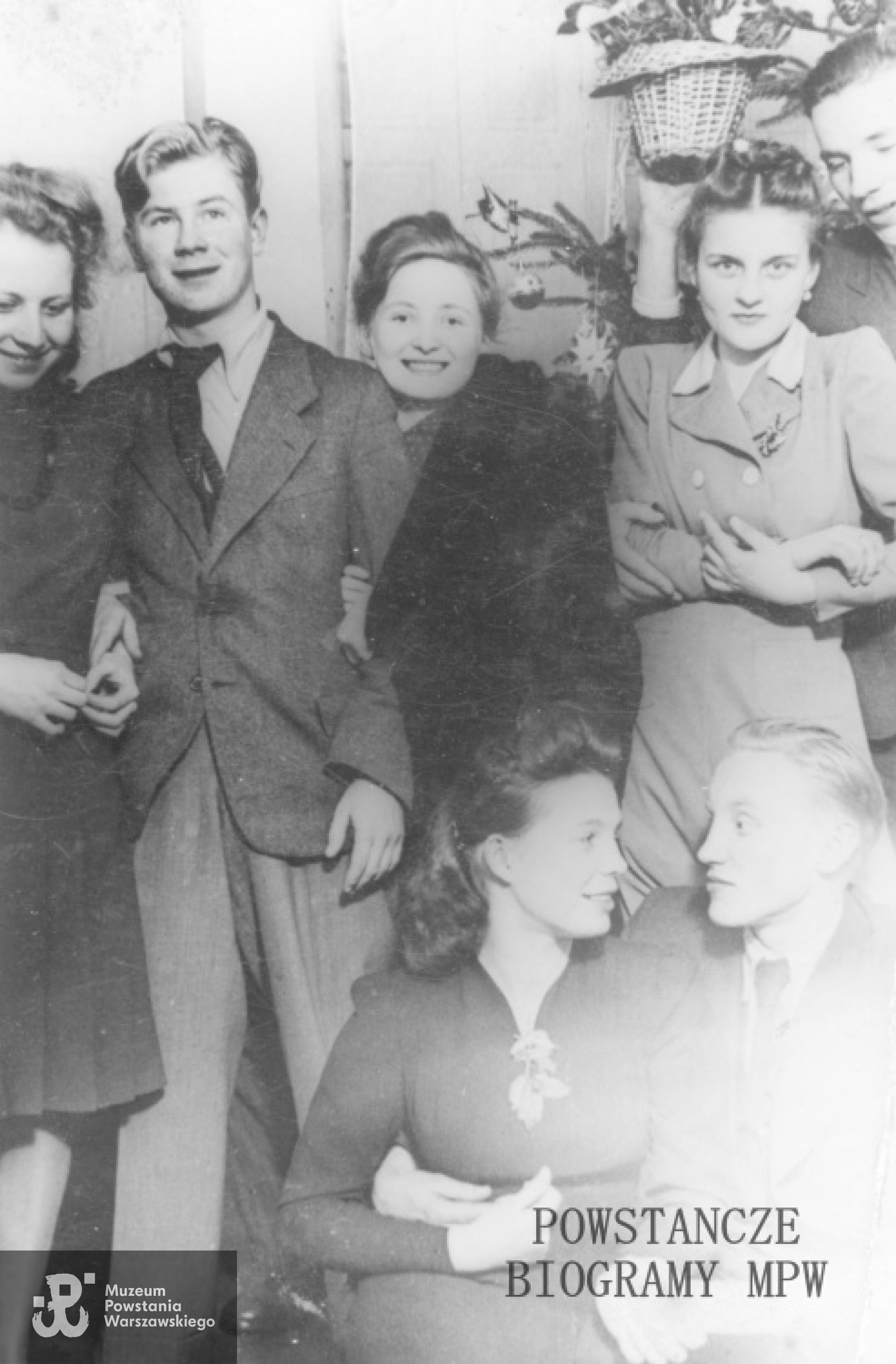 Fotografia z okresu okupacji niemieckiej.Grupa młodzieży z Szarych Szeregów podczas spotkania w mieszkaniu prywatnym. Pierwsza z lewej Krystyna Biernacka-Mikołajczyk "Kali", druga od prawej Grażyna Wiśniewska-Czyżewska "Halszka". Kucają Anna Złoch - Mizikowska" ps. "Grażka" i Stanisław Świętochowski ps. "Sęp".. Fot. ze zbiorów Muzeum Powstania Warszawskiego, sygn. MPW-IS/722