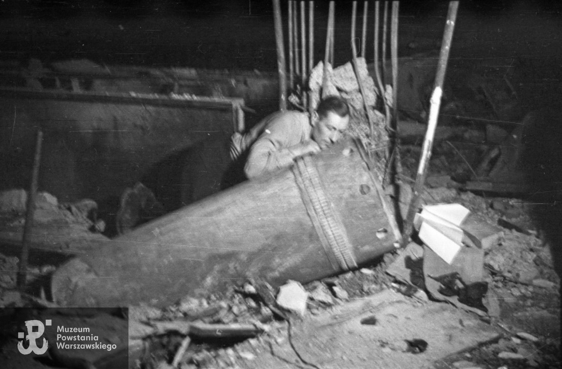 St. sierż. Józef Gorzkowski "Szczepcio" podczas rozbrajania niewybuchu pocisku w restauracji "Adria" przy ulicy Moniuszki 10. Fotografia  autorstwa Eugeniusza Lokajskiego „Broka”, zbiory Fototeki  MPW, sygn.  MPW-IN/389.  Prawa autorskie: MPW