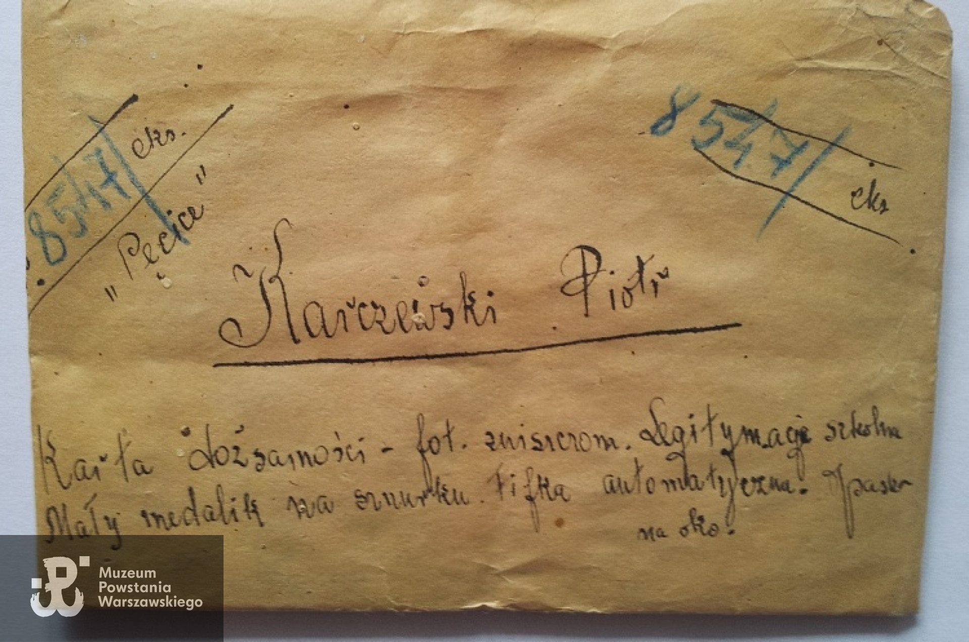 Zdjęcie prowizorycznej koperty z odręczną informacją komisji ekshumacyjnej z wyszczególnionymi dokumentami jakie koperta zawiera: Kennkarte, legitymacja szkolna, medalik, obrazek święty i inne) Kopertę otrzymała rodzina od komisji ekshumacyjnej. Fot. Monika Fila - archiwum rodzinne.