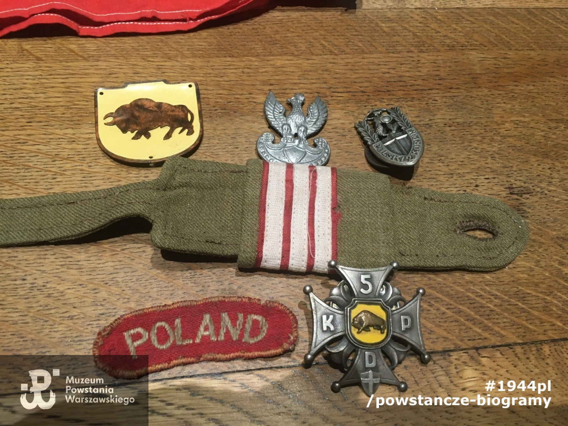 Naszywki mundurowe z okreu służby w 2 Korpusie Polskim  (widoczna m. in. naszywka 5 Kresowej Dywizja Piechoty - oznakę  stanowił żubr na żółtej tarczy w brązowej obwódce) oraz odznaka 5 KDP. Na zdjęciu widoczna także naszywka "Poland" długości około sześć do ośmiu centymetrów w kształcie łuku z czerwonego sukna, z napisem haftowanym białym jedwabiem lub srebrną nicią, która naszywana była na obu rękawach bluzy, kurtki i płaszcza, w odległości półtora centymetra od wszycia naramienników. Ze zbiorów p. Tomasza Łasicy.