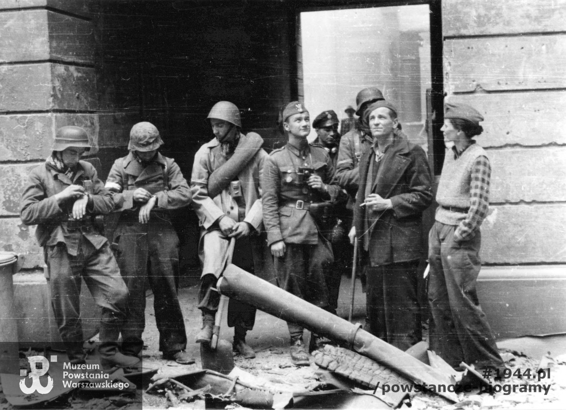 Fotografia z Powstania Warszawskiego. Śródmieście Północne. Grupa powstańców z kompanii "Koszta" prawdopodobnie przed bramą na podwórzu kamienicy przy ul. Moniuszki 7. Od prawej: Zofia Domańska "Zocha" oraz mjr Stefan Mich "Kmita". Autorem zdjęcia jest Eugeniusz Lokajski "Brok". Fot. ze zbiorów Muzeum Powstania Warszawskiego, sygn. MPW-IN/821