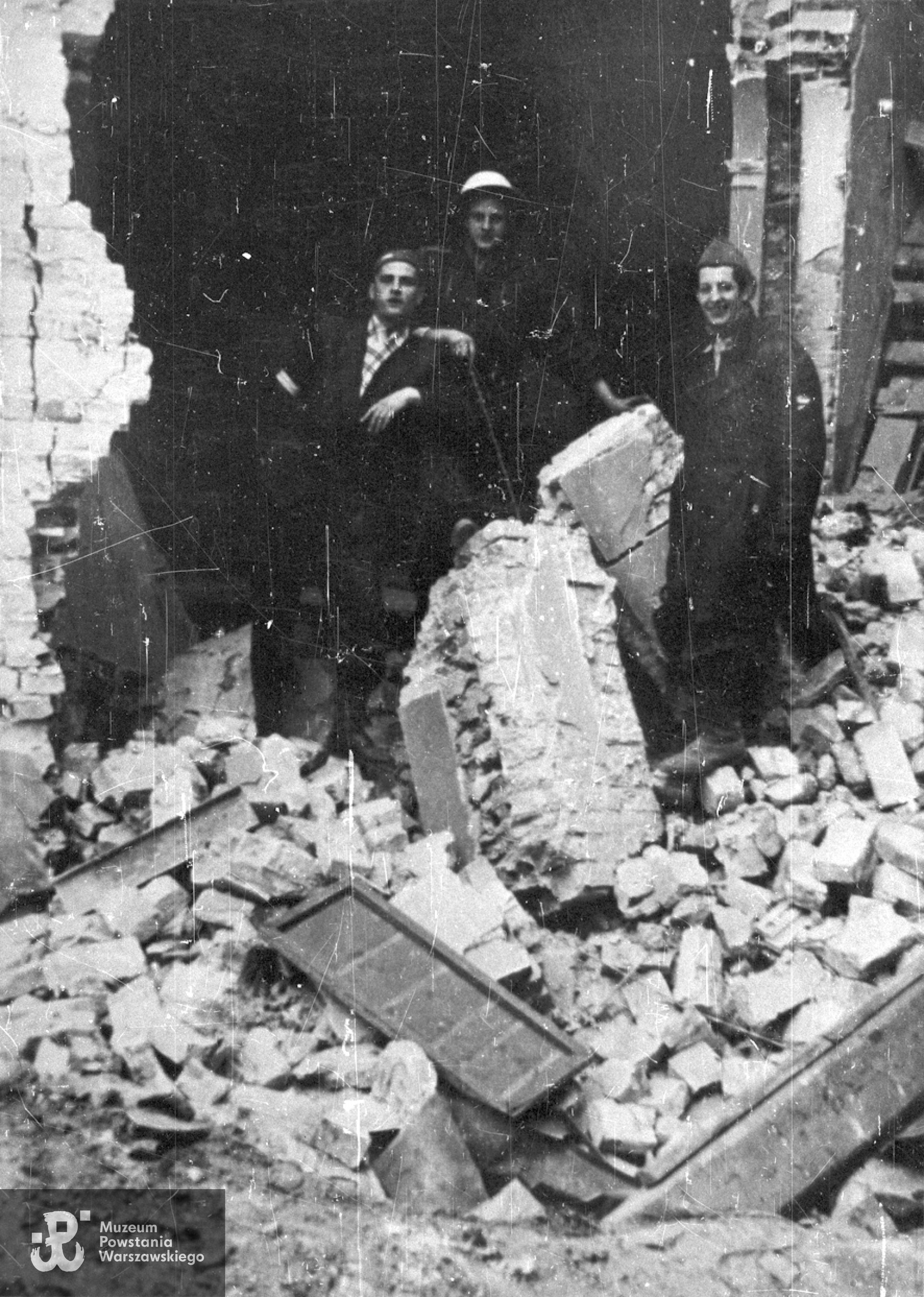 Wrzesień 1944 r. Śródmieście Południowe, ul. Śniadeckich. Żołnierze batalionu "Chrobry I" na ruinach kapliczki na terenie szpitala polowego AK na ul. Śniadeckich 17 (był to ewakuowany z ul. Senatorskiej Szpital Maltański). Stoją od lewej: Bronisław Borowski, NN, st. strz. Zygmunt Ochmański "Lusia". Ze zbiorów Muzeum Powstania Warszawskiego,  sygn.  MPW-IN/8758.