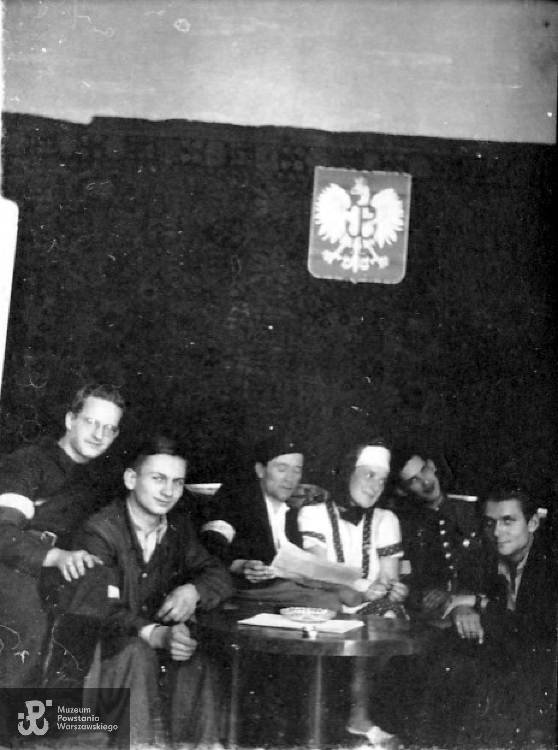 Koniec sierpnia 1944 r. - żołnierze II plutonu  „Skobig” w powstańczej świetlicy mieszczącej się budynku przy ul. Poznańskiej. Lech Kożuchowski siedzi drugi od prawej. Archiwum Lecha Kożuchowskiego.