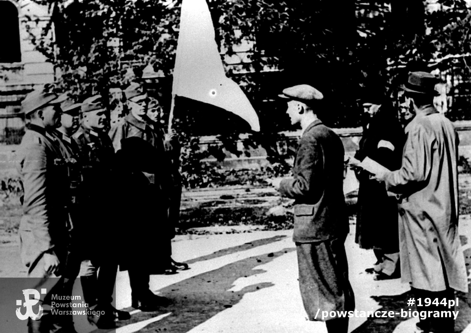 Fotografia z Powstania Warszawskiego. Śródmieście Południowe. Parlamentariusze polscy na ul. 6 Sierpnia (obecnie Nowowiejska) udają się na pertraktacje w sprawie kapitulacji Powstania. W tle gmach Politechniki Warszawskiej; po lewej delegacja niemiecka; po prawej delegacja polska: dr Hieronim Bartoszewski, Maria hrabina Tarnowska, ppłk dypl. Bohdan Zieliński „Tytus Barski”, por. Alfred Korczyński „Sas”, fot. NN, Warszawa, 29 września 1944 r. Fot. ze zbiorów Muzeum Powstania Warszawskiego, sygn. MPW-IH/4272
