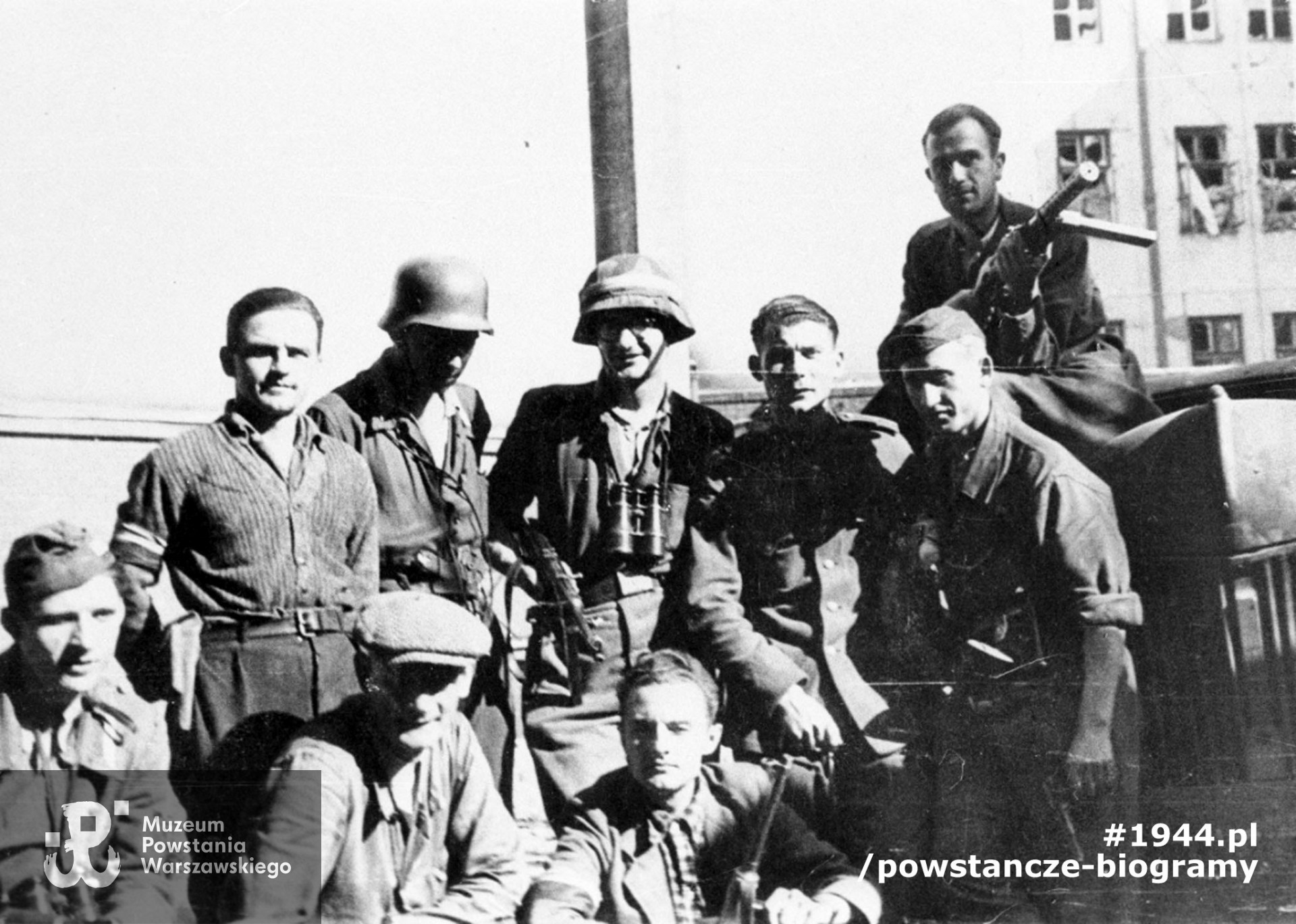Fotografia z Powstania Warszawskiego. Grupa powstańców z kompanii "Tadeusz" batalionu "Ruczaj" na wewnętrznym dziedzińcu budynku Poselstwa Czechosłowackiego Koszykowa 18.  Stoją od lewej: kpr. Wiktor Bykowski "Jacek", NN, por. Władysław Zajdler "Żarski". Pozostałe osoby nierozpoznane. Fot. ze zbiorów Muzeum Powstania Warszawskiego, sygn. MPW-IH/3743