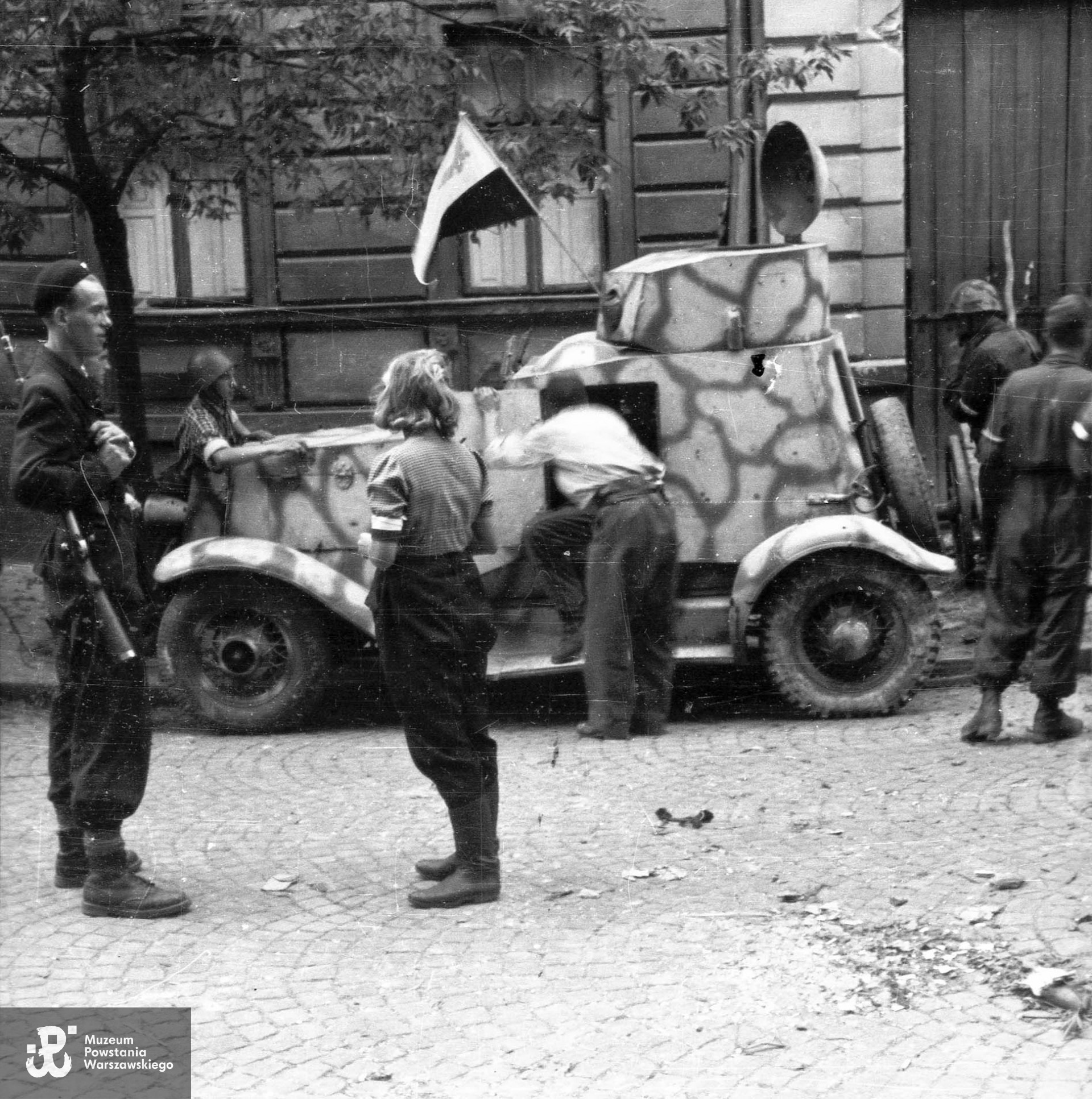 Fotografia z Powstania Warszawskiego. Zdobyty przez Powstańców samochód opancerzony (sowiecki BA-20) na ul. Kruczej na styku kamienic nr 3 i 5. Pierwszy od lewej Wojciech Tabaczkiewicz "Narwicz". Tyłem stoi  Janina Szaters (po m. Podsiad) z centrali telefonicznej Zgrupowania "Ruczaj".  Autorem zdjęcia jest Stanisław Dobrzyński. Fot. ze zbiorów Muzeum Powstania Warszawskiego, sygn. MPW-IH/1765. Identyfikacji Wojciecha Tabaczkiewicza ps. Narwicz dokonała p.  Barbara Lulińska, siostra cioteczna Powstańca.