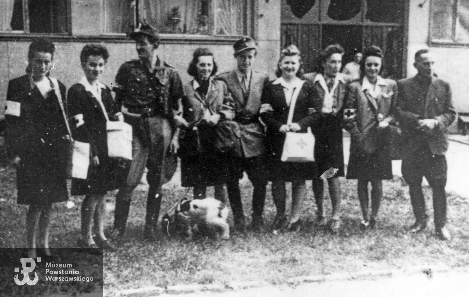 Sanitariuszki z patrolu sanitarnego 107 plutonu, 3 kompanii. VIII Zgrupowania kpt. „Krybara" na Powiślu wraz z kolegami z plutonu. Od lewej: sanitariuszka Jadwiga Zdunek-Kozłowska ps. „Wrońska", sanitariuszka Barbara Zawada ps. „Basia", dowódca plutonu kpr. pchor. Bogdan Schodowski ps. „Bartnicki", patrolowa Barbara Kleck-Rosłoniec ps. „Zagórowska". z-ca d-cy plut. kpr. pchor. Stefan Kączkowski ps. „Wichajster", sanitariuszka Janina Linkowska-Bałlaban ps. „Tomaska", nie należąca do patrolu Irena Jedlińska-Popławska ps. „Irys", sanitariuszka Anna Siemińska-Raczyńska, ps. „Ania " i oficer 2 kompanii ppor. Władysław Szella ps. „Dowgird". Fot. w zbiorach Muzeum Powstania Warszawskiego, sygn. MPW-IK/2955. Autor zdjęcia nieznany