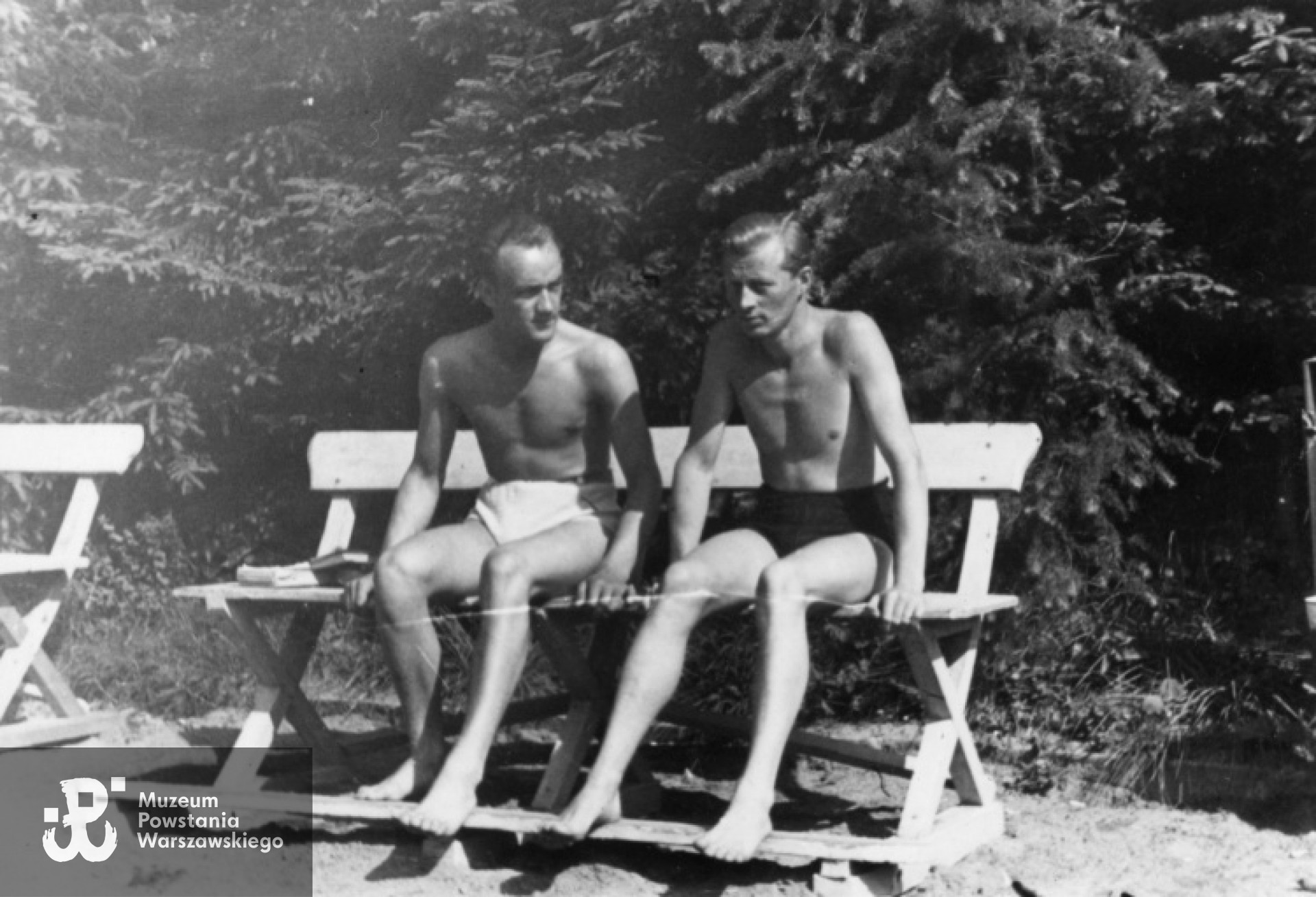 Fotografia z okresu okupacji niemieckiej, lipiec 1942. Krynica. Jerzy (po lewej) i Tadeusz Dobrzańscy na jednej z ławek nieopodal basenu. Fot. Olgierd Budrewicz, zbiory Fototeki MPW