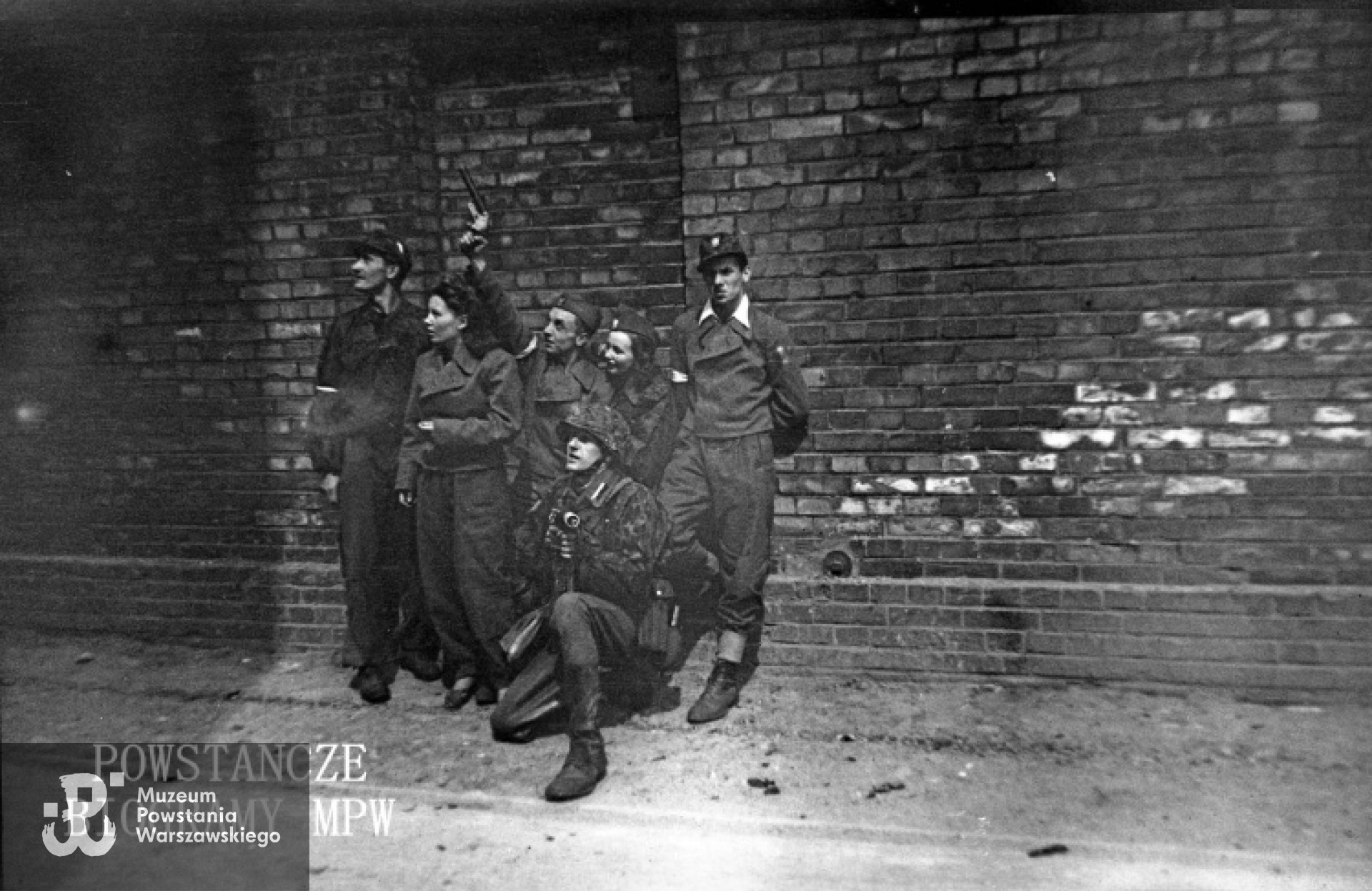 Grupa powstańców z Batalionu "Miotła" pluton "Torpedy", od lewej: ppor. Marian Ławacz "Marek", łączniczka Krystyna Trzaska "Krysia", plut. pchor. Zenon Jackowski "Adam Horski", Danuta Marciniak - Aniszewska "Danka", kpr. pchor. Zbigniew Wojterkowski "Bogdan", klęczy plut. pchor. Jan Romańczyk "Łata". Fot. ze zbiorów Muzeum Powstania Warszawskiego, sygn. MPW-IN/4280. Autorem zdjęcia jest Jerzy Michalski "Korczak"