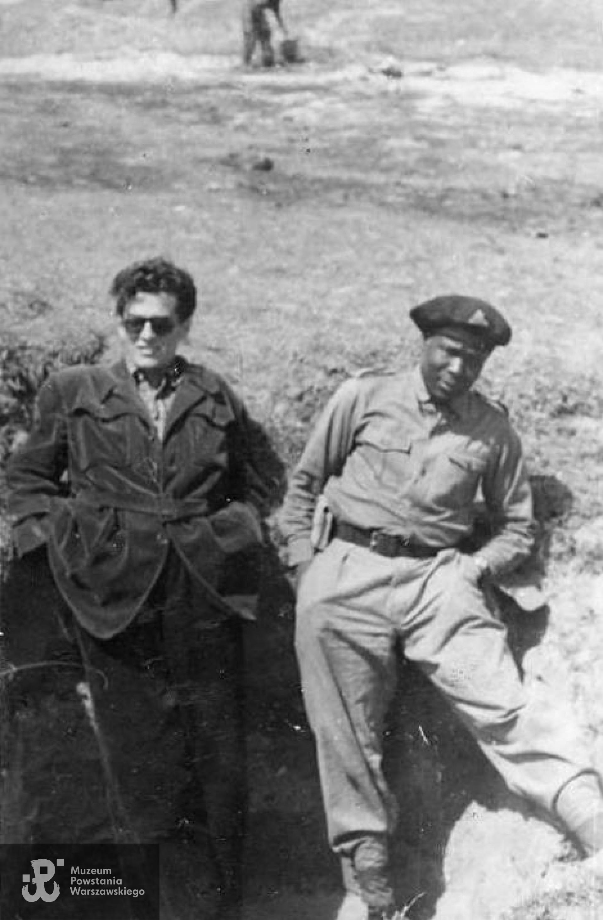 Zdjęcie wykonane  na planie filmowym "Żołnierza zwycięstwa" (1953) w reżyserii Wandy Jakubowskiej. Po lewej  Adam Hanuszkiewicz, po prawej August Agbola O'Brown. Skan udostępniony Pokojowi Kombatanta MPW przez córki.
