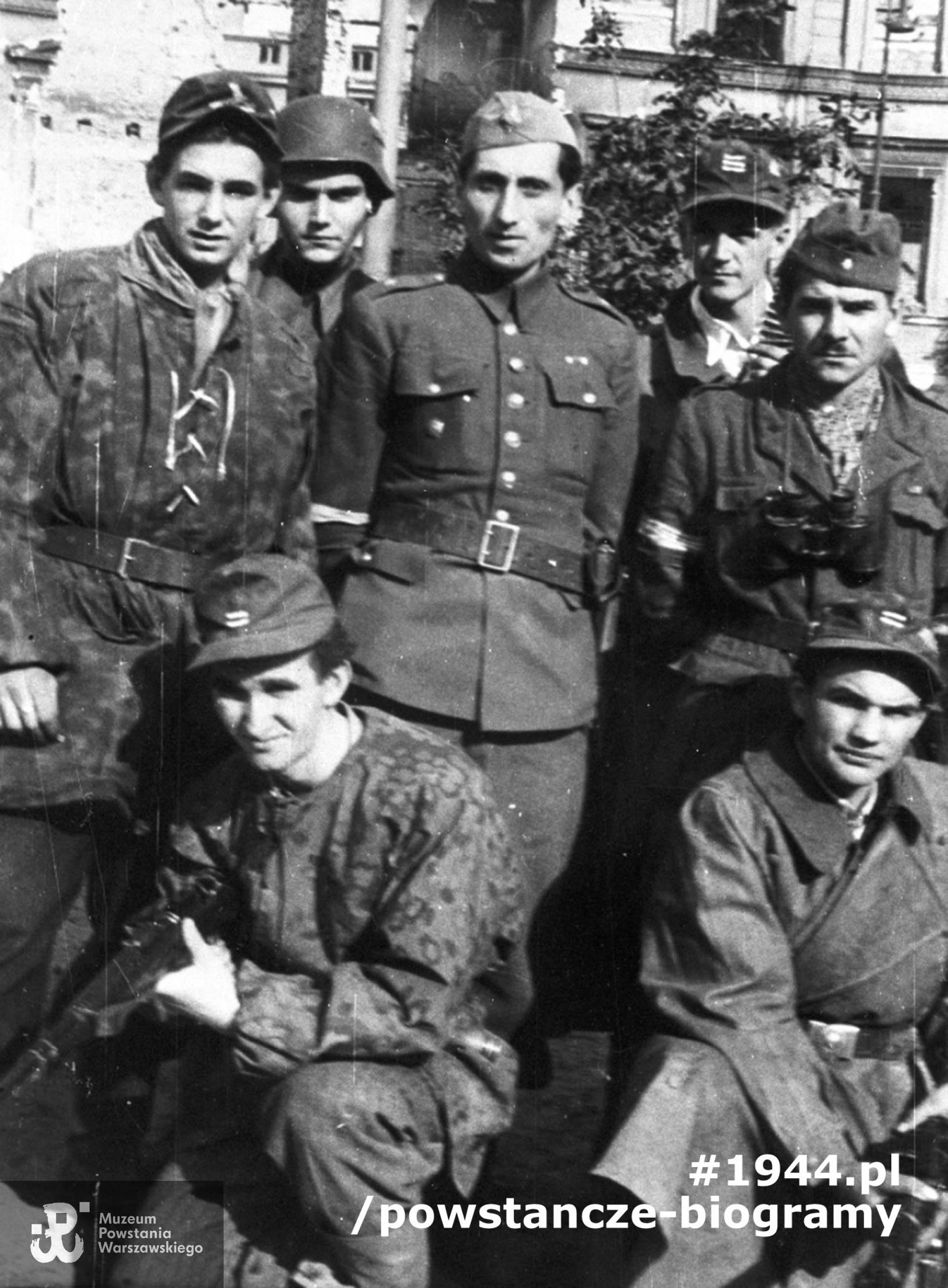 Fotografia z Powstania Warszawskiego, por. Wojciech Pszczółkowski "Kostka" (na zdjęciu w środku) z żołnierzami OS "Juliusz", w Śródmieściu włączonym do  zgrupowania AK "Bartkiewicz". Plac Dąbrowskiego, najprawdopodobniej wrzesień 1944 r. Ze zbiorów Muzeum Powstania Warszawskiego, sygn. MPW-IH/4821