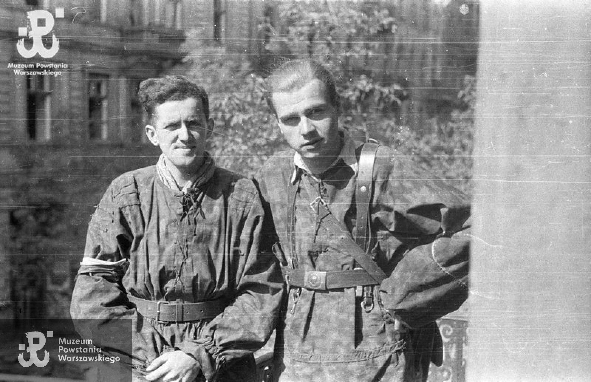 Fotografia z Powstania Warszawskiego. Śródmieście Południowe. Powstańcy z kompanii „Anna” Batalionu „Gustaw” na balkonie domu przy ulicy Wilczej 16. Ujęcie z mieszkania siostry autora zdjęcia, Hanki. Od lewej: kpr. Jerzy Sikorski „Sixton” i ppor. Jerzy Siwiec „Jur” .Autorem zdjęcia jest Wiesław Chrzanowski „Wiesław”. Fot. ze zbiorów Muzeum Powstania Warszawskiego, sygn. MPW-IN/3289