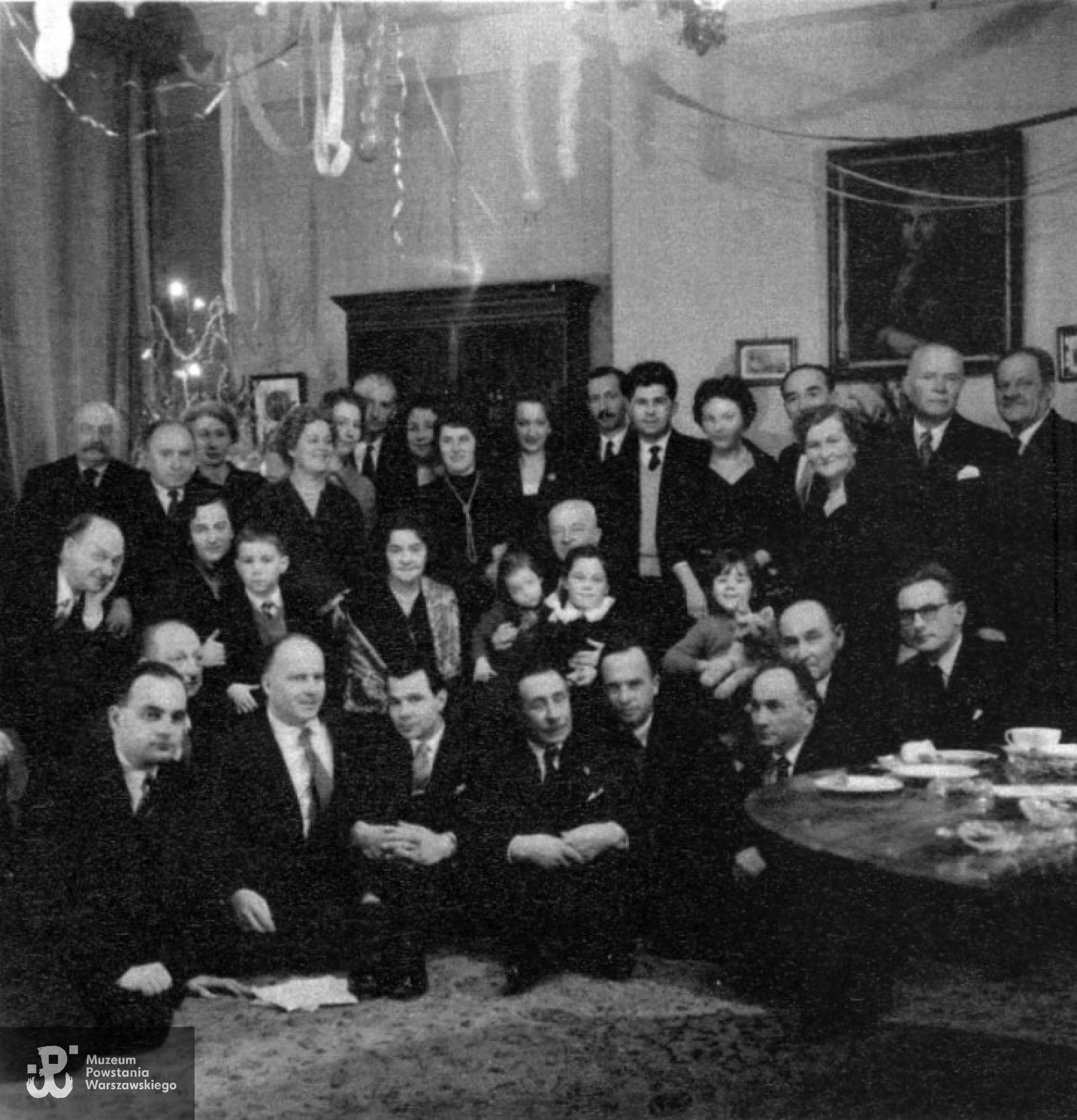 Opłatek Koła 7 Pułku Ułanów Lubelskich w Ognisku Polskim, Krzysztof Głuchowski klęczy pierwszy od prawej. Londyn, styczeń 1960 rok. Fot. z archiwum rodzinnego Krzysztofa Głuchowskiego.