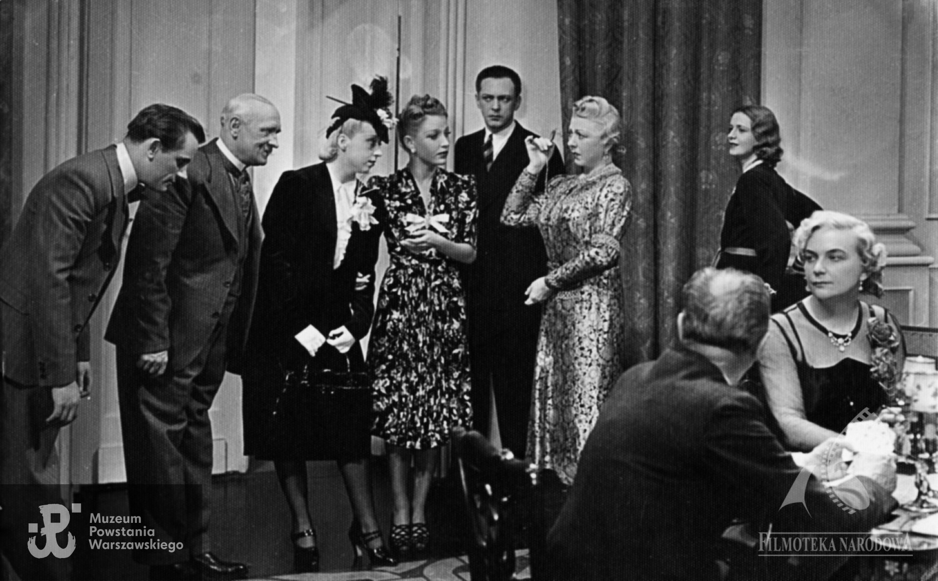 Kadr z filmu "Złota maska" z 1939 r.  (scena niewykorzystana w filmie). Widoczni na zdjęciu: Józef Orwid, Lidia Wysocka (czwarta z lewej), Aleksander Żabczyński (piąty z lewej), Mieczysława Ćwiklińska (szósta z lewej), Irena Wasiutyńska (stoi z prawej), Jerzy Kobusz Jerzy (z lewej)  i niezidentyfikowana aktorka  (trzecia z lewej). Ze zbiorów Filmoteki Narodowej - Instytut Audiowizualny (FINA)
