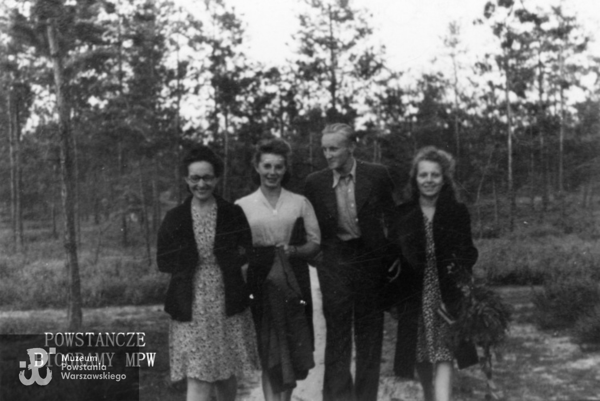 Fotografia z okresu okupacji niemieckiej. Okolice Warszawy. Konspiracyjne szkolenie wojskowe w lasach na linii otwockiej (Michalin-Józefów). Dziewczęta z zastępu "Pędziwiatrów" z drużyny Grupa Wykonawcza przy Kwaterze Głównej Szarych Szeregów. Od lewej: zastępowa Hanna Darda ps. "Ala", Anna Złoch (po mężu Mizikowska) ps. "Grażka" i Krystyna Biernacka ps. "Kali". Pomiędzy nimi Stanisław Świętochowski ps. "Sęp". Fot. ze zbiorów Muzeum Powstania warszawskiego, sygn. MPW-IS/740