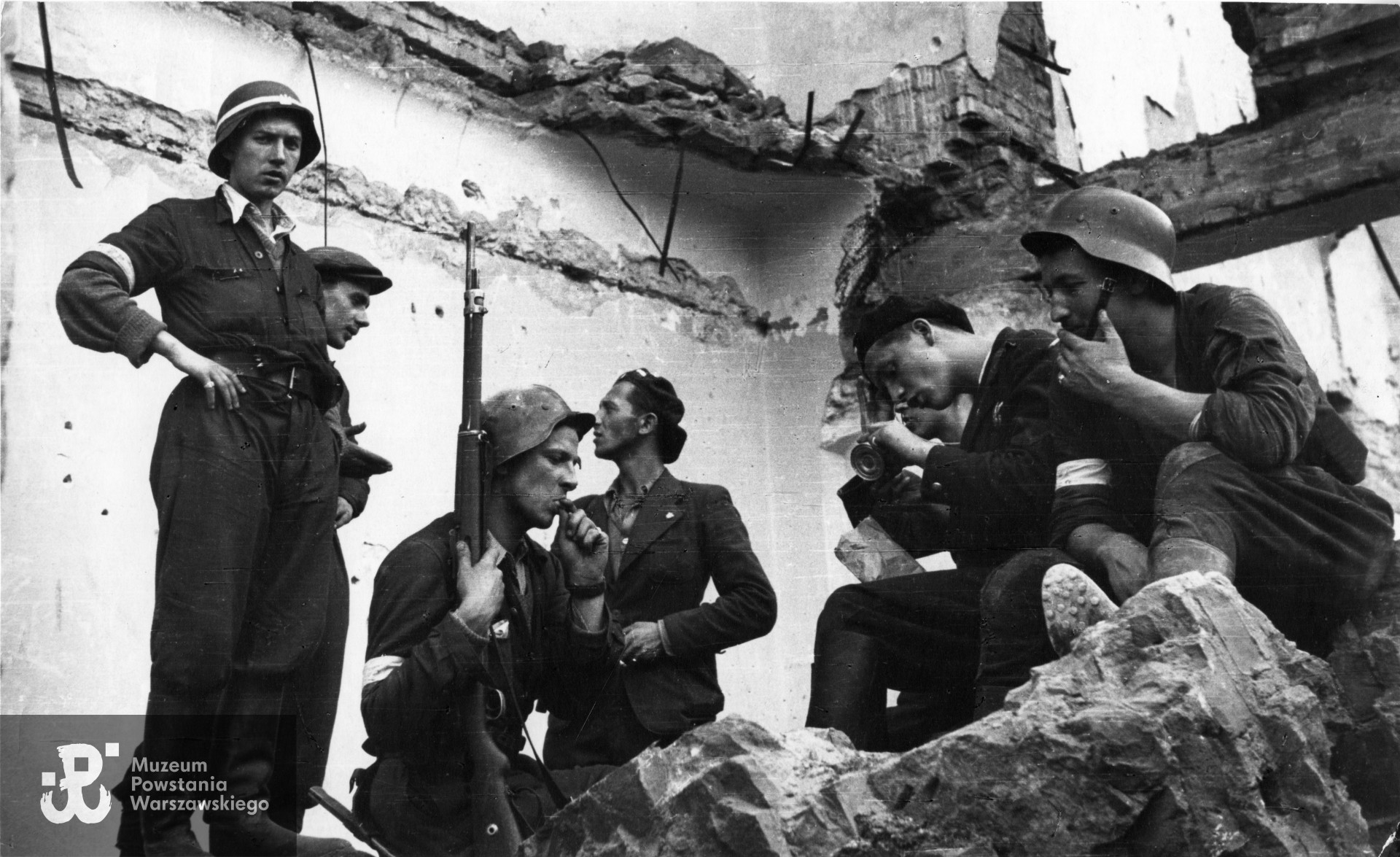 Żołnierze ”Perkuna„ zgrupowanie majora ”Bartkiewicza„ w ruinach domu na rogu Świętokrzyskiej i Mazowieckiej. [Od lewej] Józef Skoniecki ”Bąk„, Wacław Żukowski ”Walter„, Jerzy Płaczkiewicz ”Jur„, Tadeusz Wrzesiński ”Parowóz„, Janusz Jastrzębski ”Niebora„ (w hełmie z paskiem pod brodą z papierosem)”. Odbitka wraz z opisem przekazana przez p. Andrzeja Jastrzębskiego, sygn. P/P/5610/07, ujęcie tożsame: MPW-IN/123. Autorem zdjęcia jest Eugeniusz Lokajski „Brok"