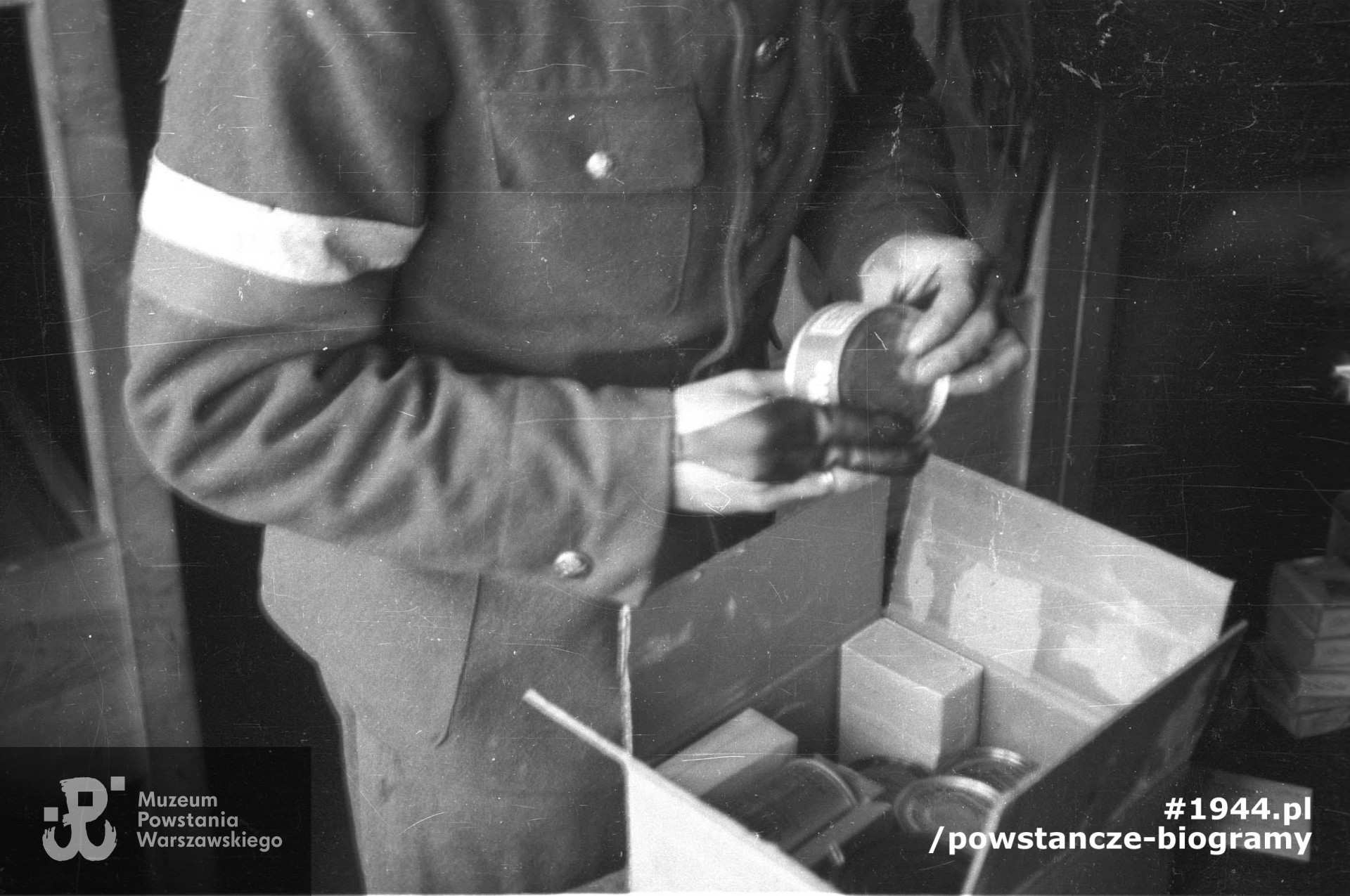 Fotografia z obozu jenieckiego - Oflagu XI B/z w Bergen-Belsen. Por. Wojciecha Sarnecki ego "Wojtka" z kompanii "Anna" Batalionu "Gustaw" rozpakowujący świąteczną paczkę ze szwajcarskiego Czerwonego Krzyża. Autorem zdjęcia jest Wiesław Chrzanowski. Ze zbiorów Muzeum Powstania Warszawskiego, sygn. MPW-IN/3377